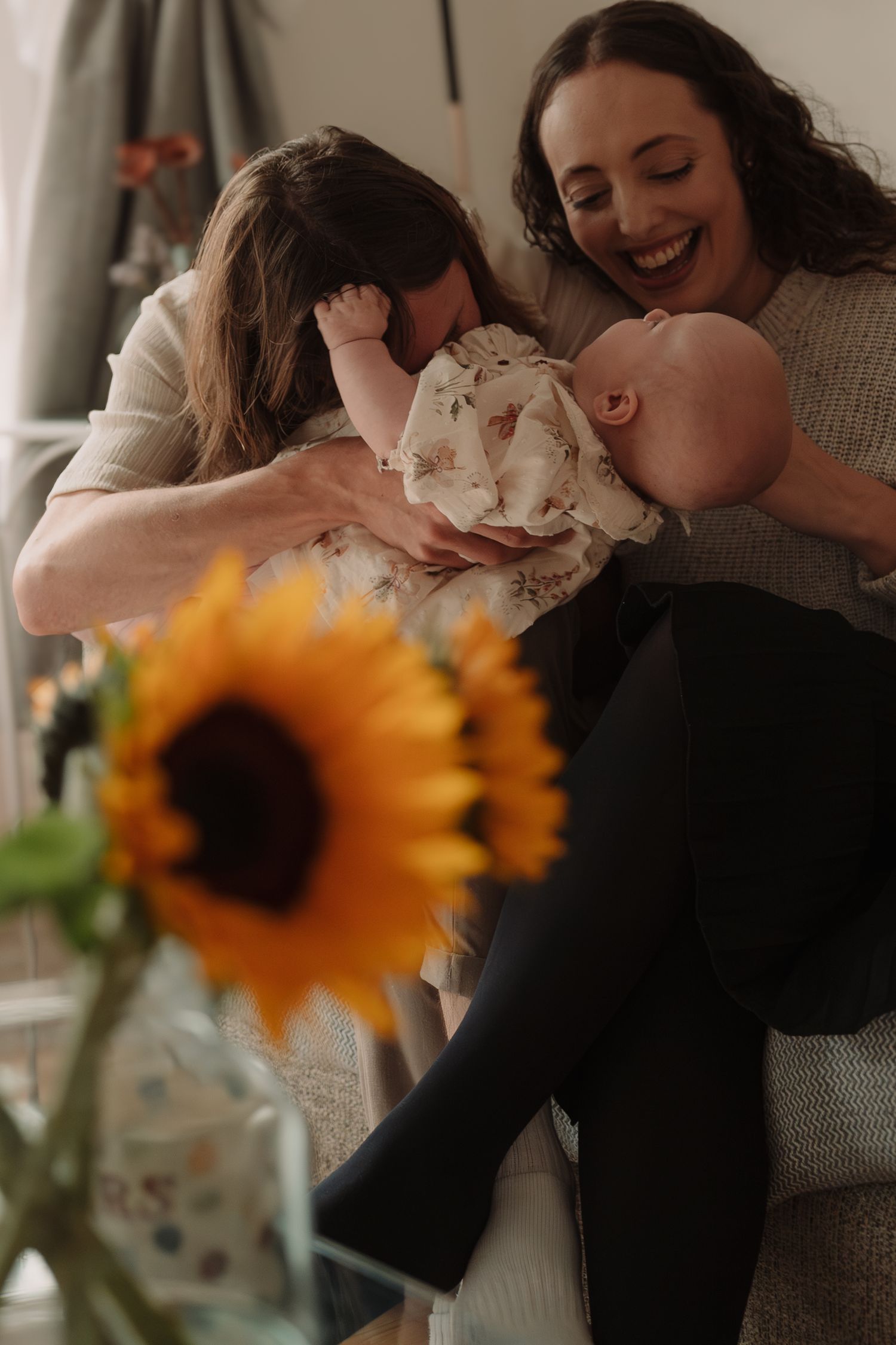 A romantic couple shares a tender moment while dancing together with bright sunflowers in the foreground.