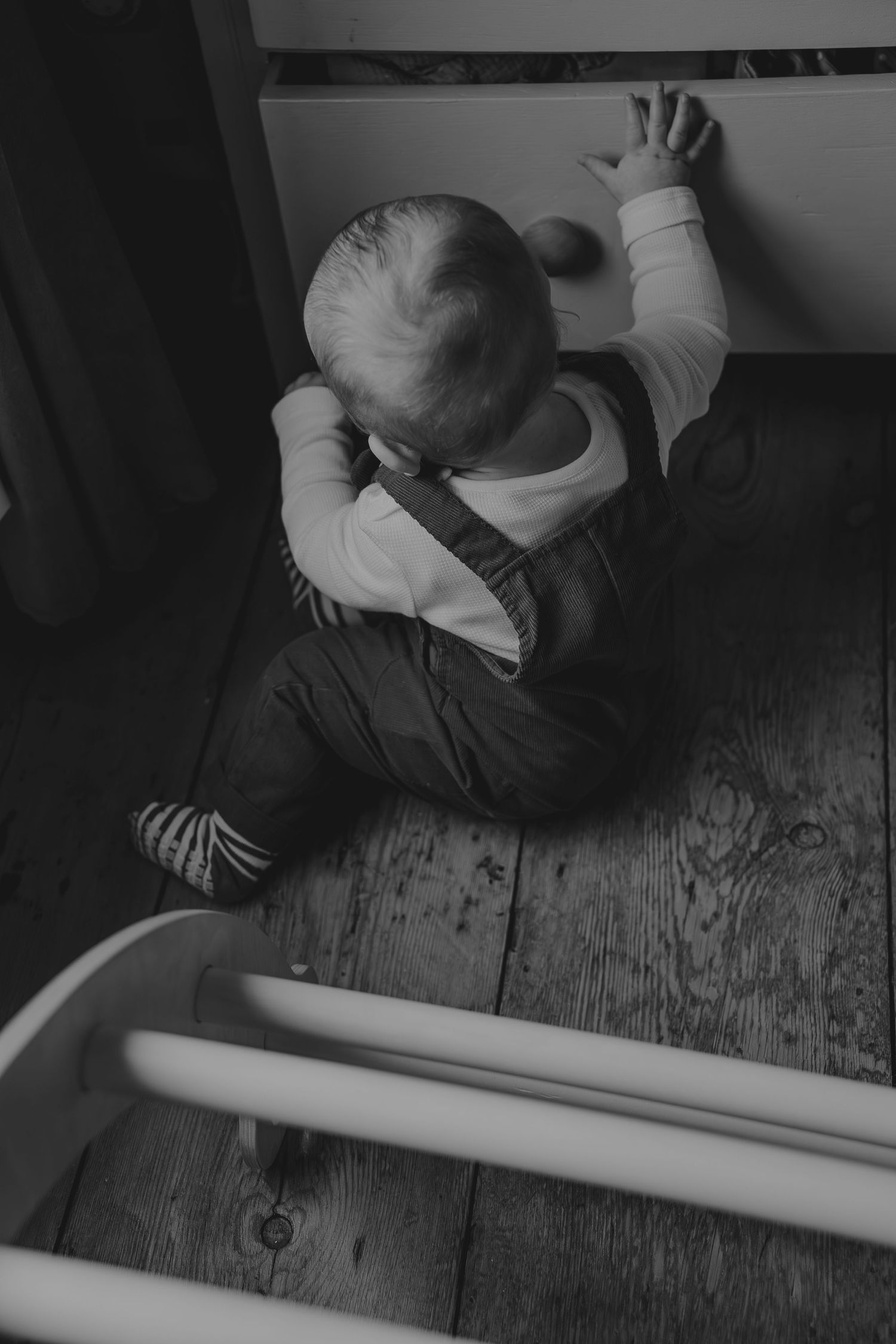A series of black and white photos showing someone working on measuring and marking a long white board on a wooden floor.