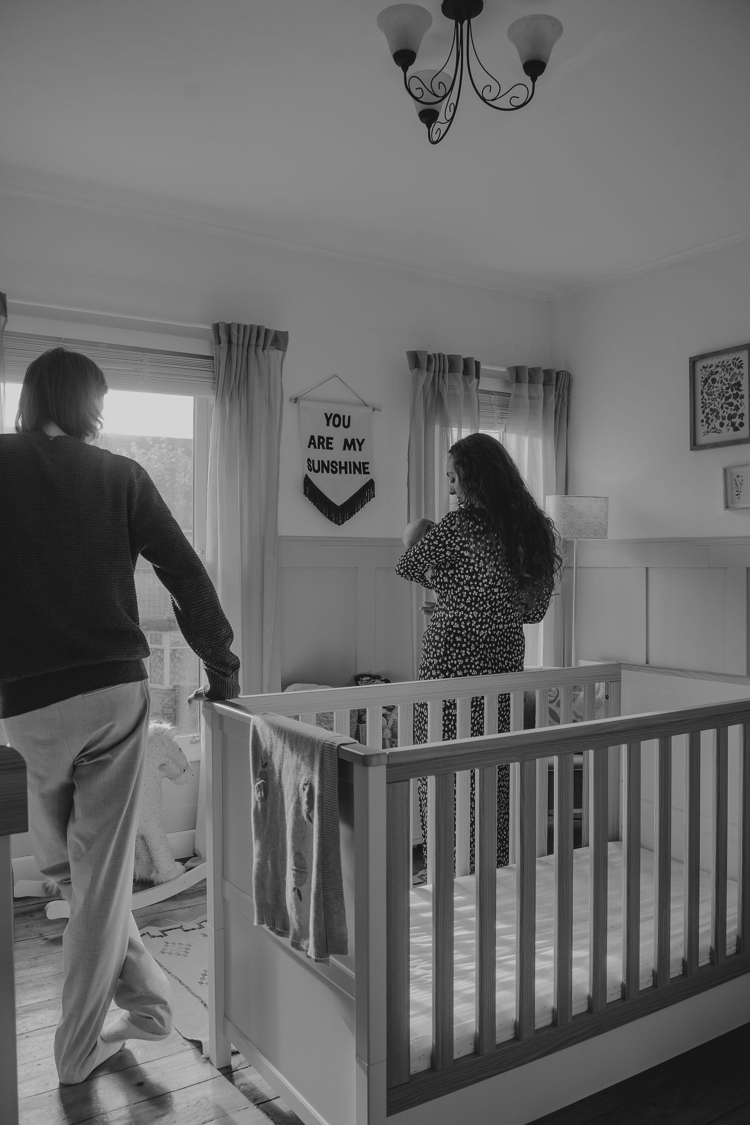 A peaceful nursery scene with a wooden crib and decorative wall banner.
