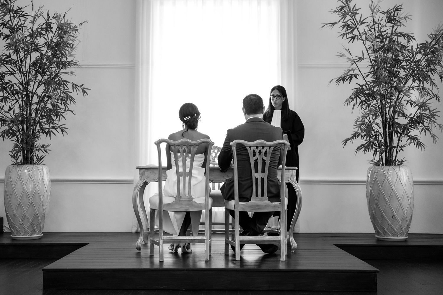 A black and white photo sequence showing silhouettes of people seated at a table in progressive frames.