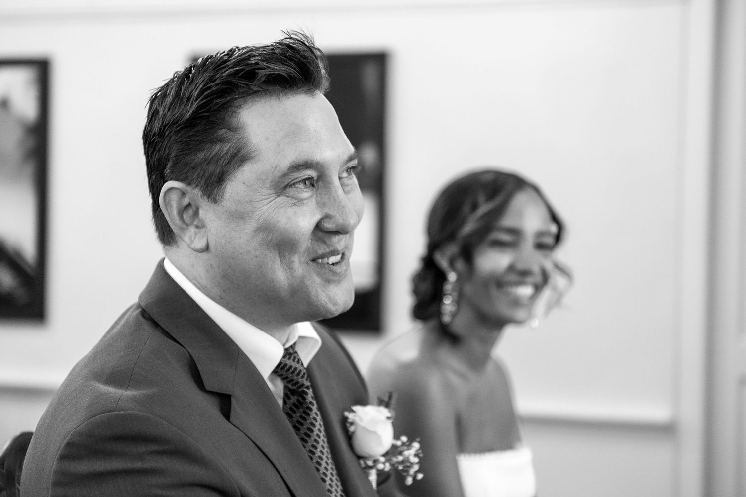 Wedding guests seated at a table share laughter and conversation during an elegant reception celebration.