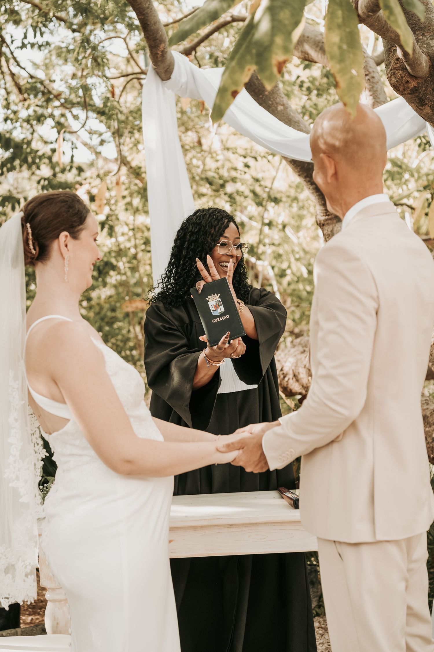 A series of candid wedding photos showing joyful moments between a couple and officiant during an outdoor ceremony.