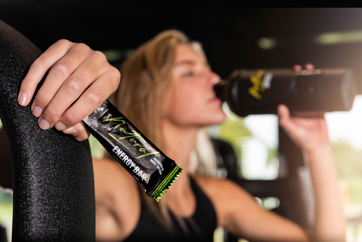 Person drinking from a glass bottle in a car at night with multiple similar images shown in sequence.
