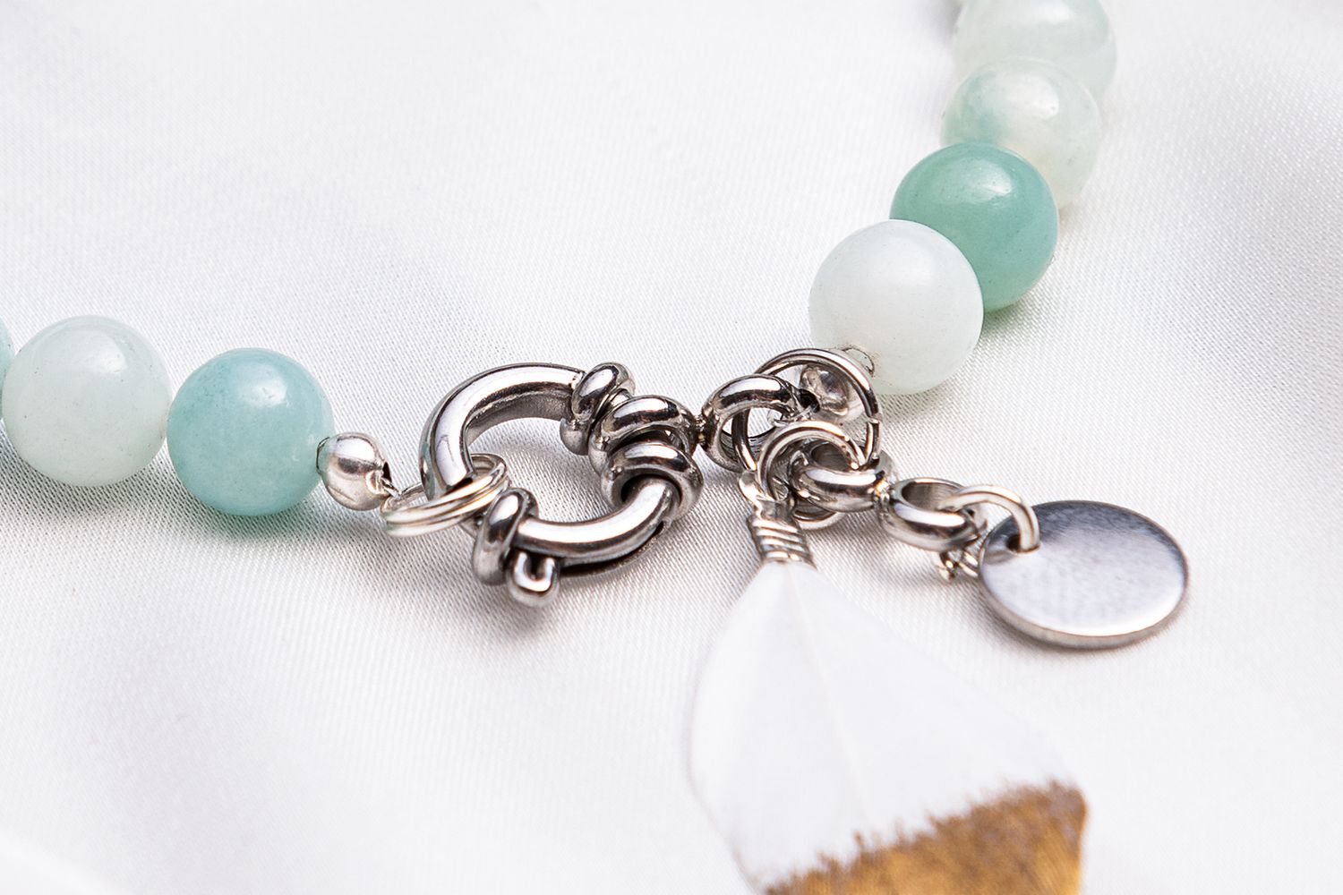 A delicate bracelet featuring alternating aqua blue and white beads with silver toggle clasp and charms.