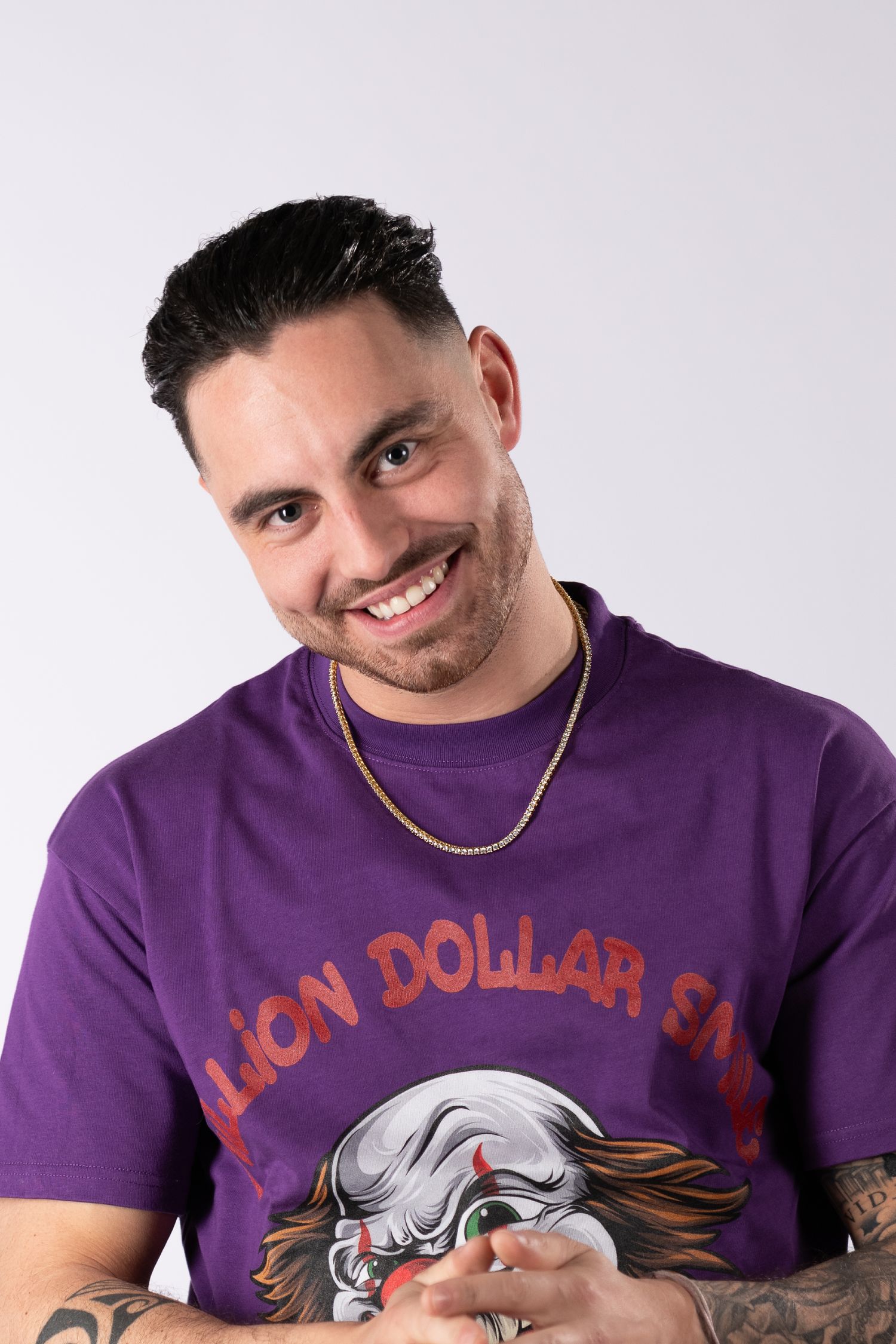 Person wearing purple t-shirt with graphic design smiling and gesturing in multiple poses.
