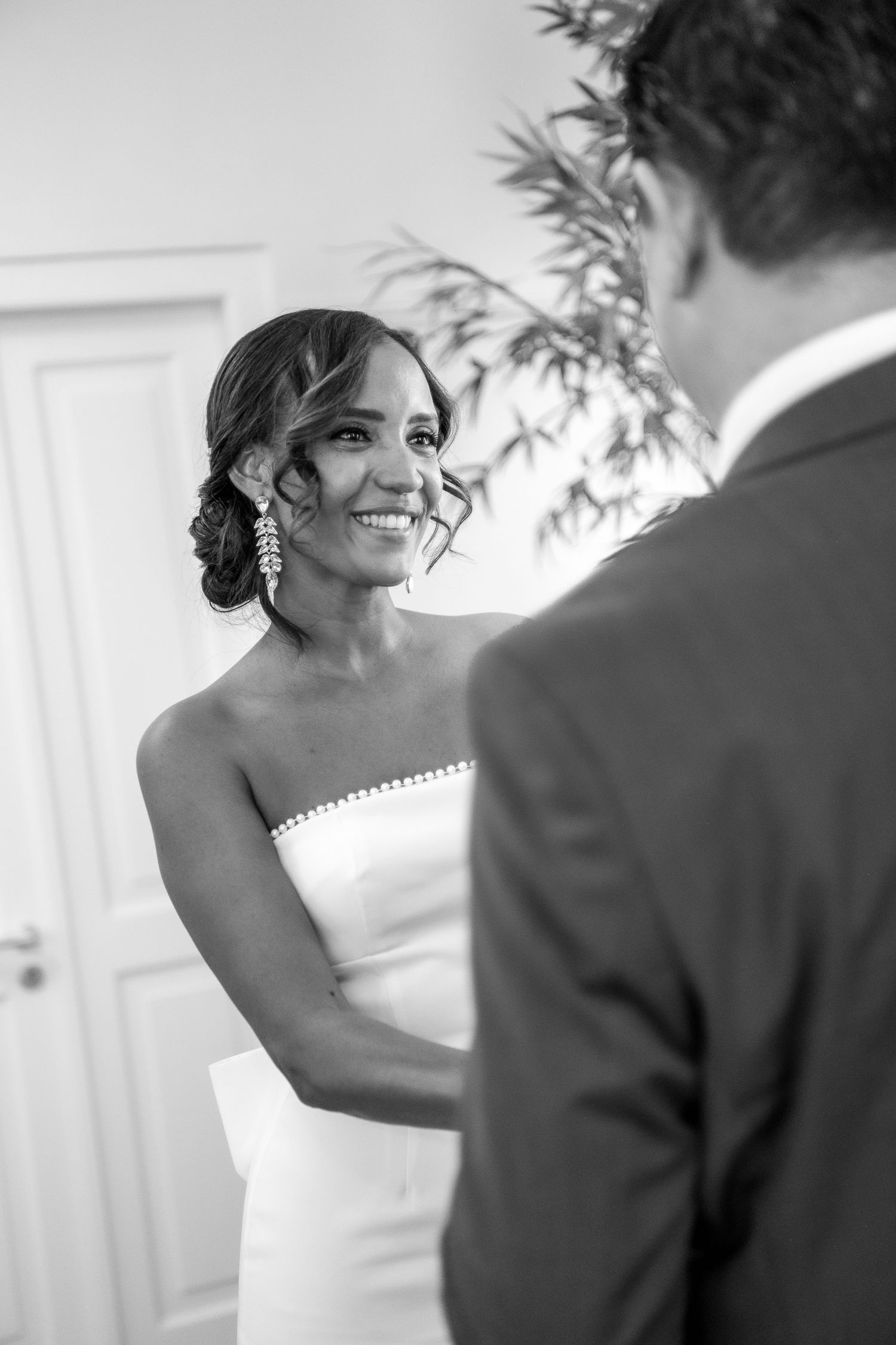 Black and white wedding photo series showing a bride and groom sharing joyful moments during their first look.