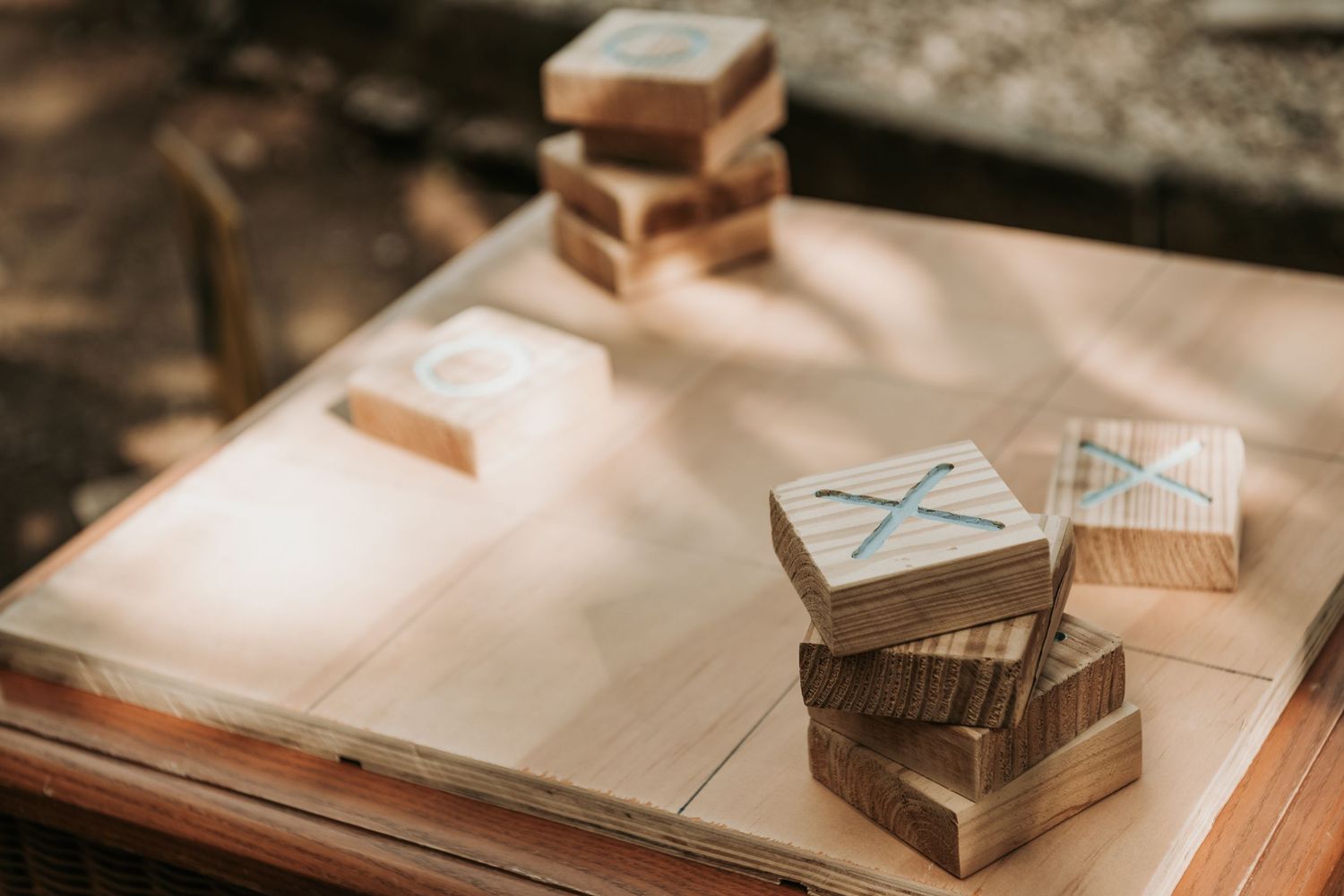 Vintage books and wooden blocks scattered on a weathered wooden surface in warm, natural lighting.