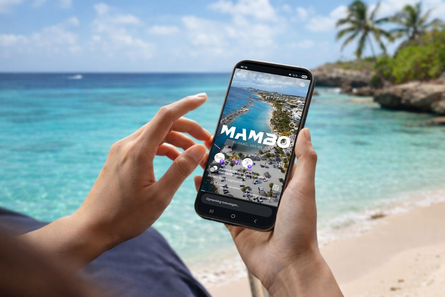 Person taking photos of a tropical beach with turquoise waters and palm trees using a smartphone camera.