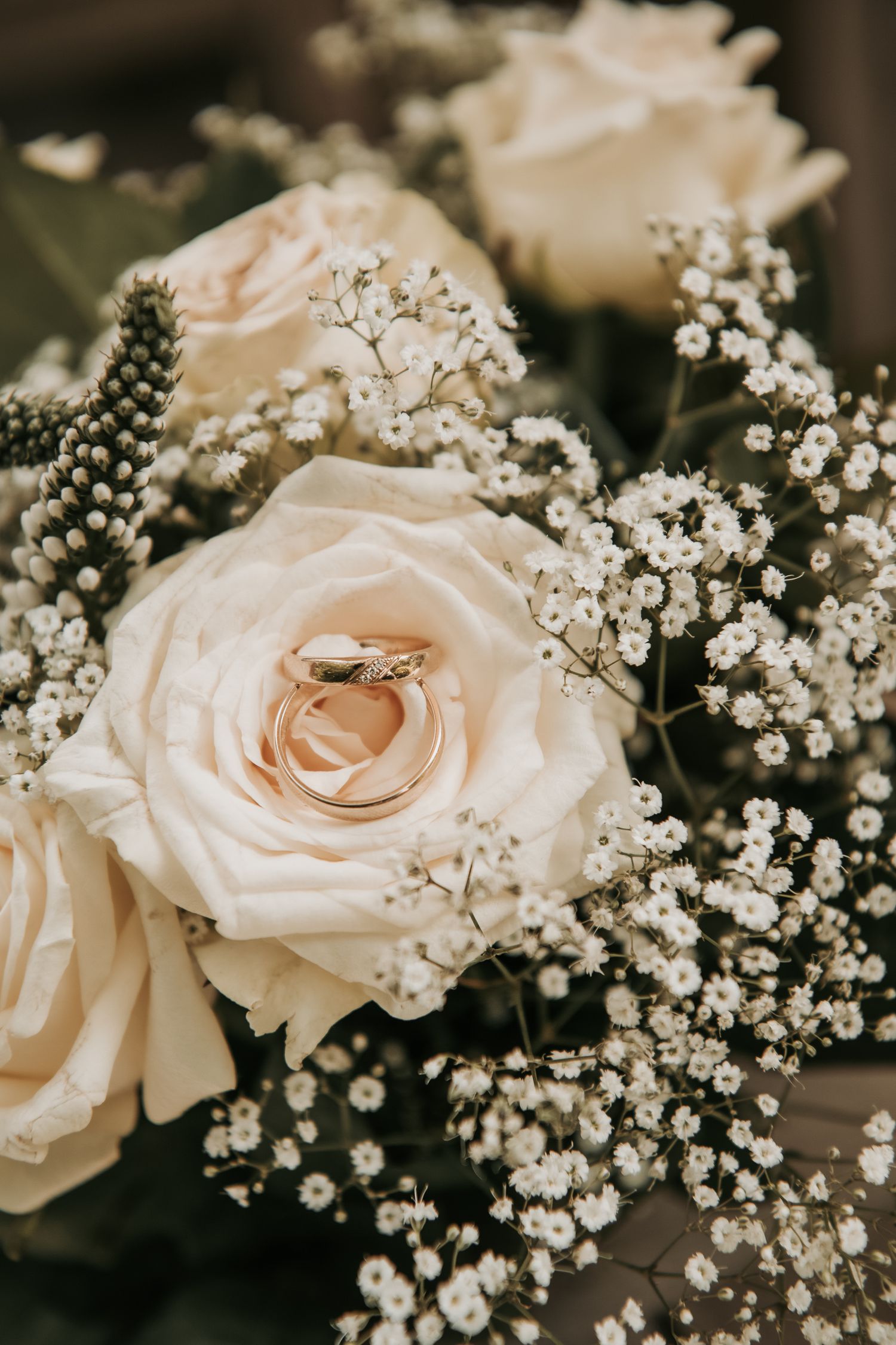 Delicate cream roses paired with white baby's breath flowers in a romantic wedding bouquet arrangement.