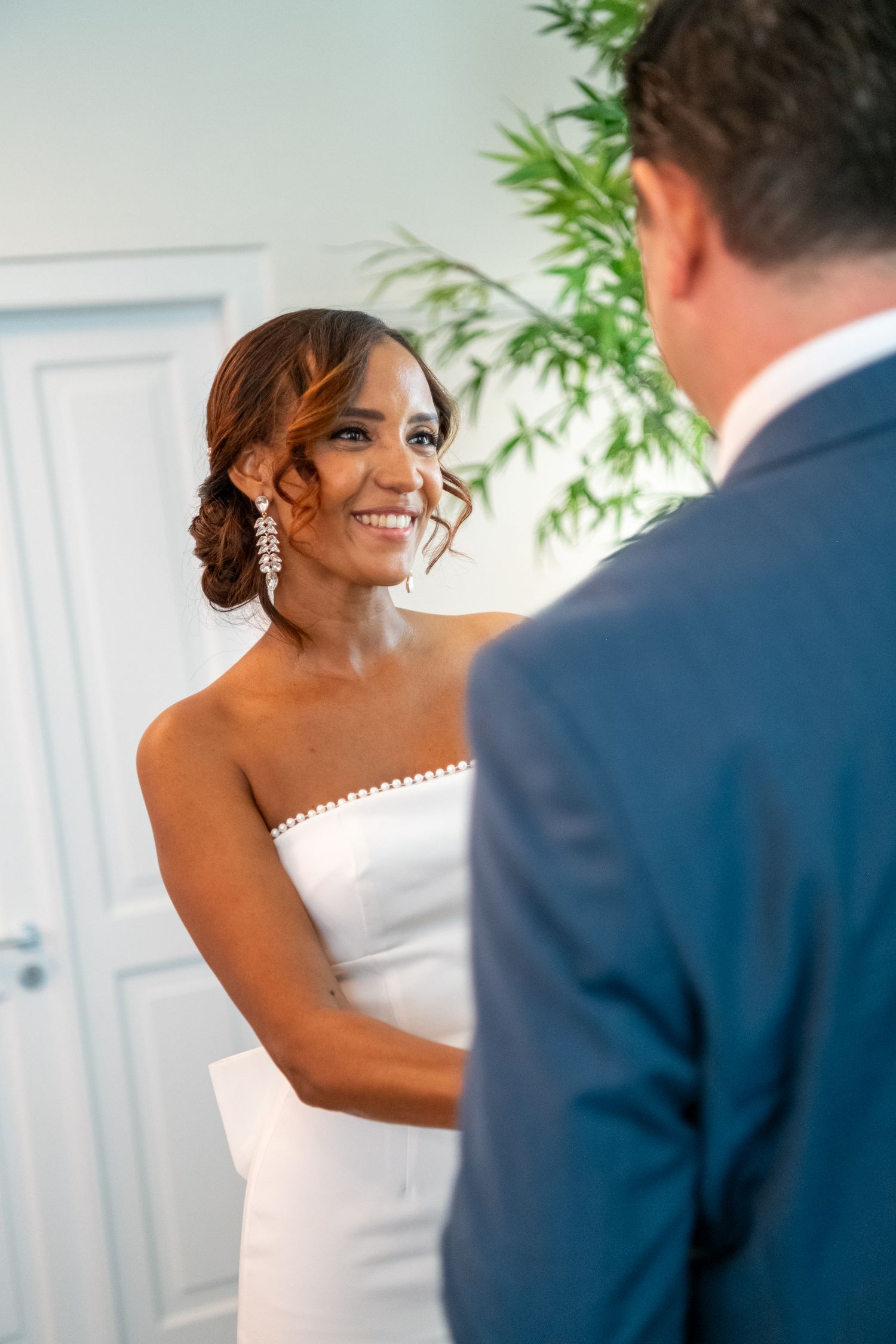 A bride in a white strapless dress shares a joyful moment during her wedding day.