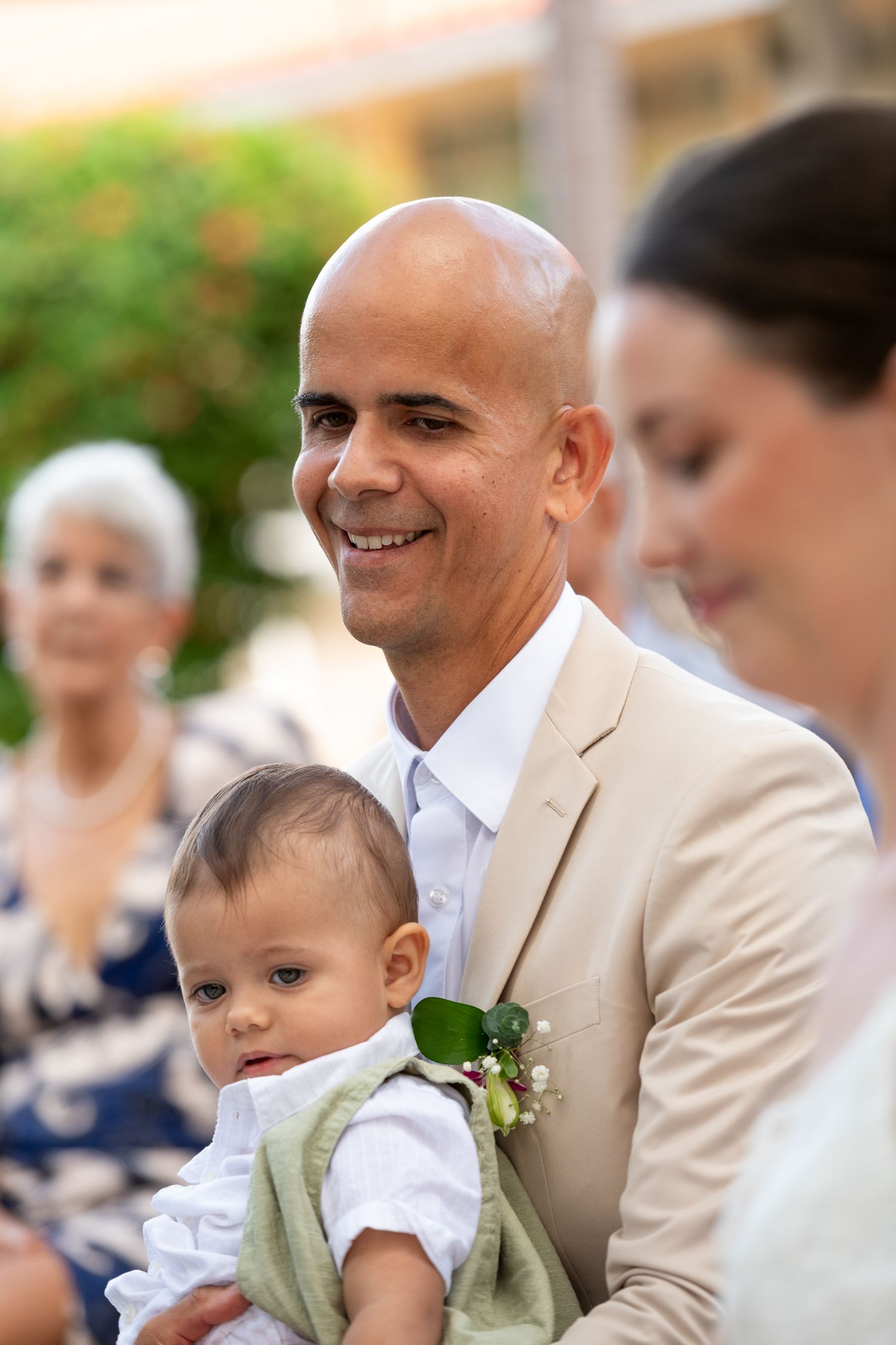 A series of candid wedding photos showing tender moments between guests and a small baby in formal attire.