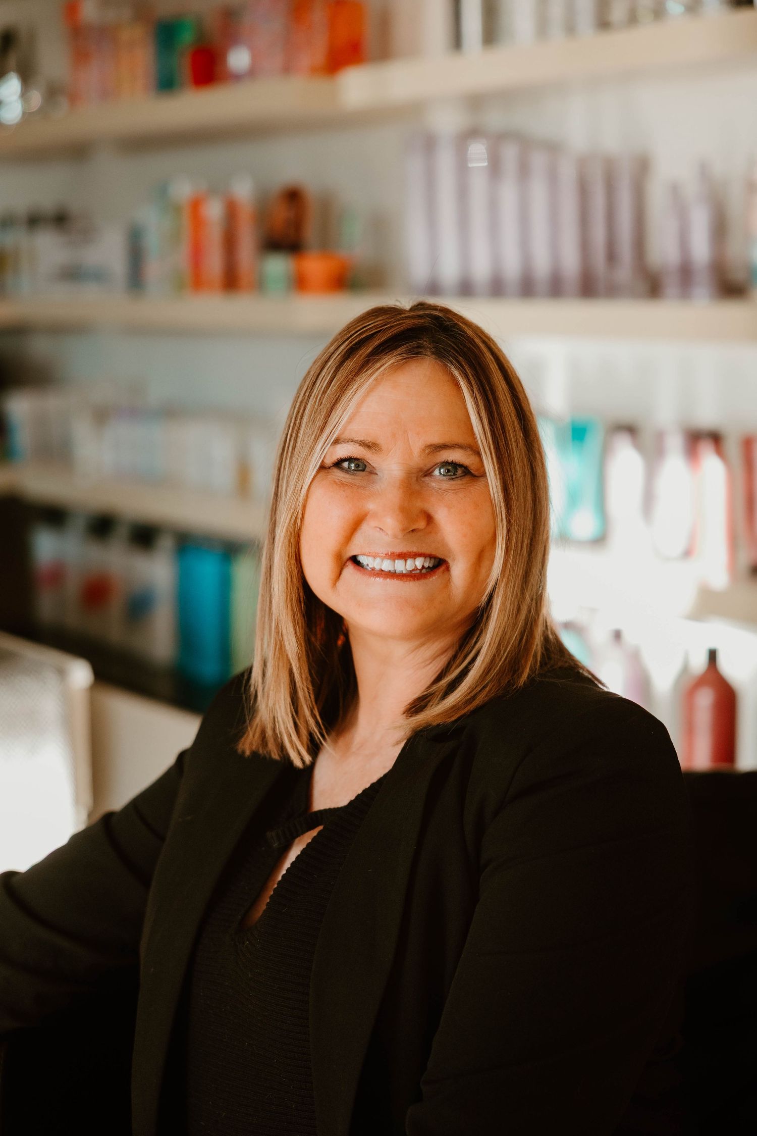 Professional portrait series showing warm smiles and expressions in a salon setting with product shelves in background.