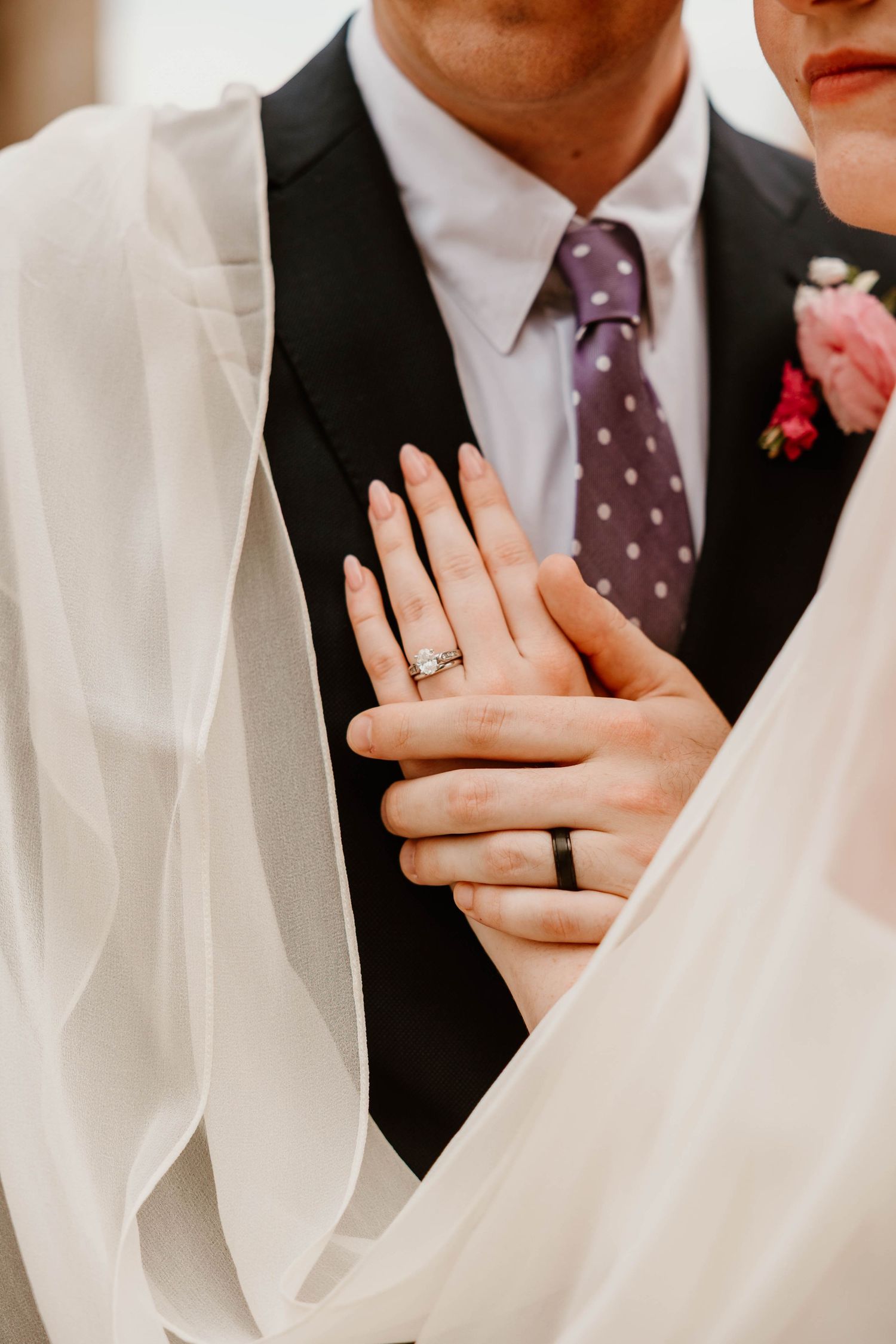 Close-up shot of wedding rings and hands during an intimate moment.