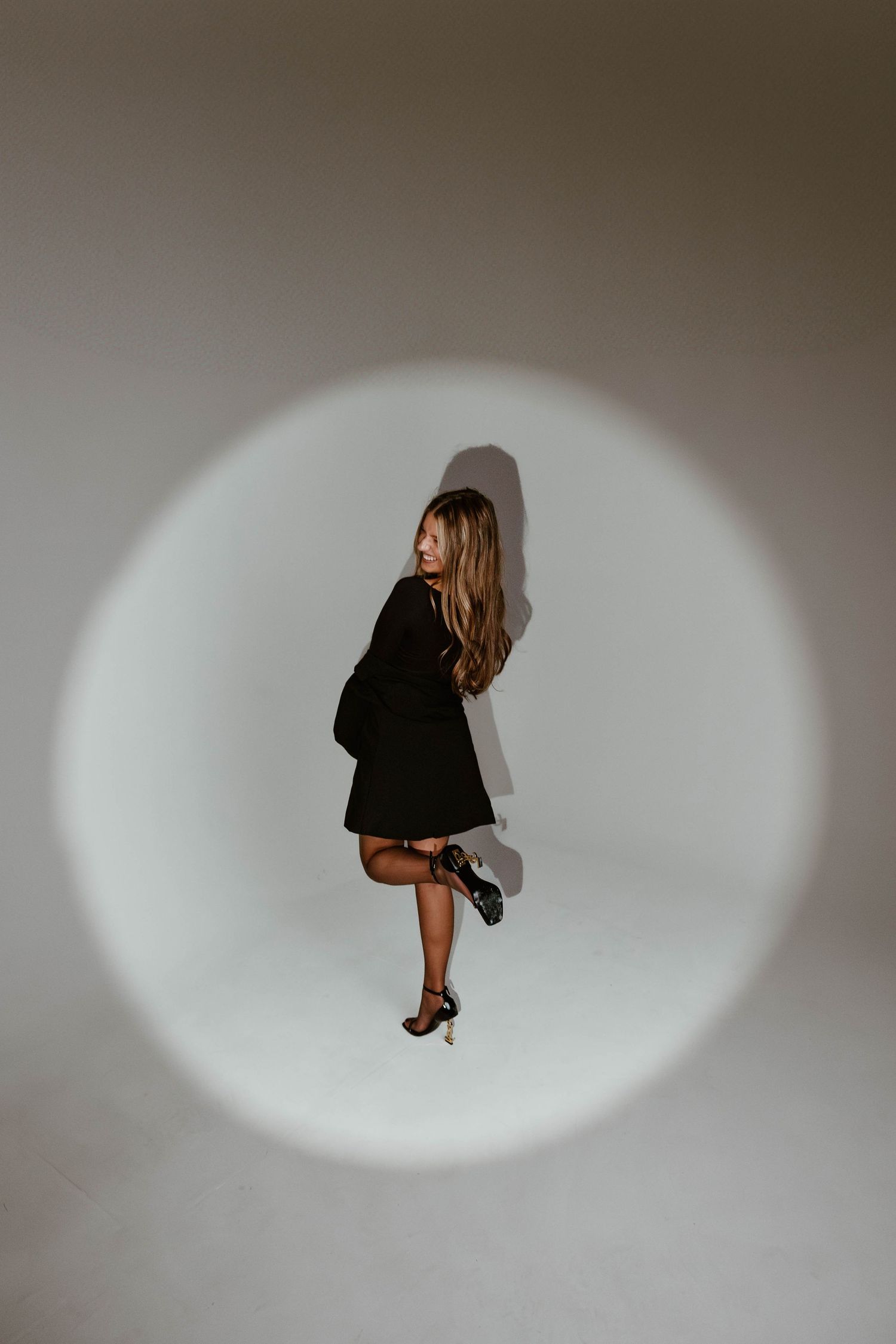Minimalist photo sequence showing a figure in black against white circular spotlight.