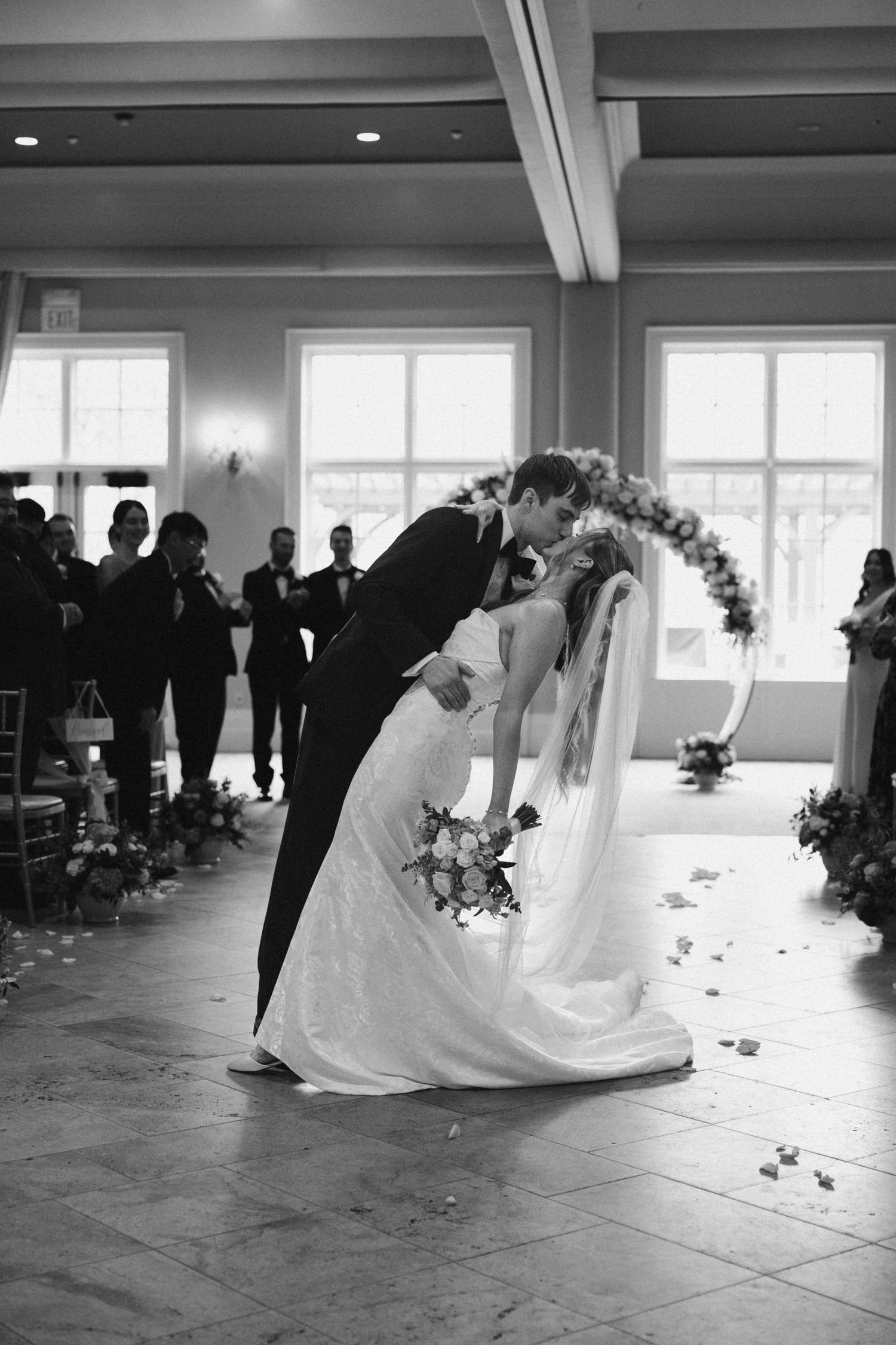Bride and groom share a romantic dip kiss at the altar during their wedding ceremony.