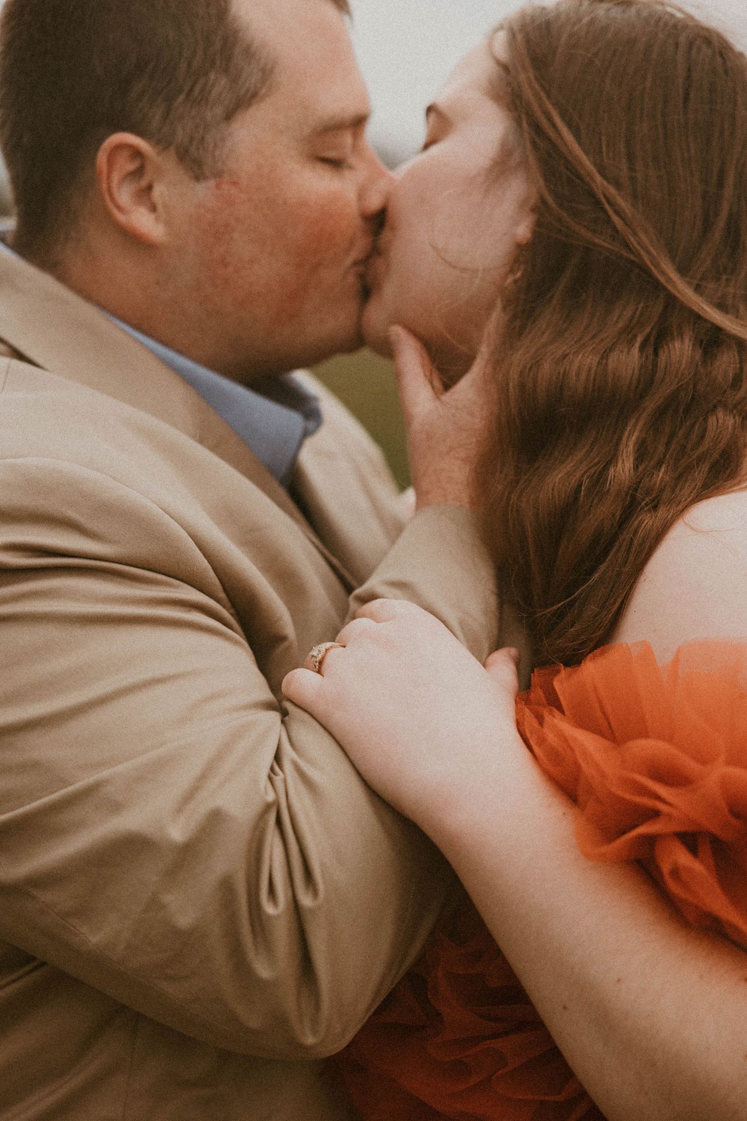 Intimate close-up photo of a couple sharing a tender moment in warm lighting.