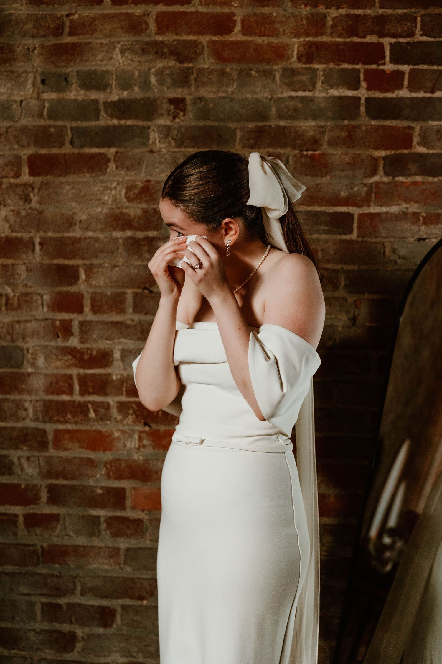 Intimate bridal portraits against rustic brick wall showing emotional moments.