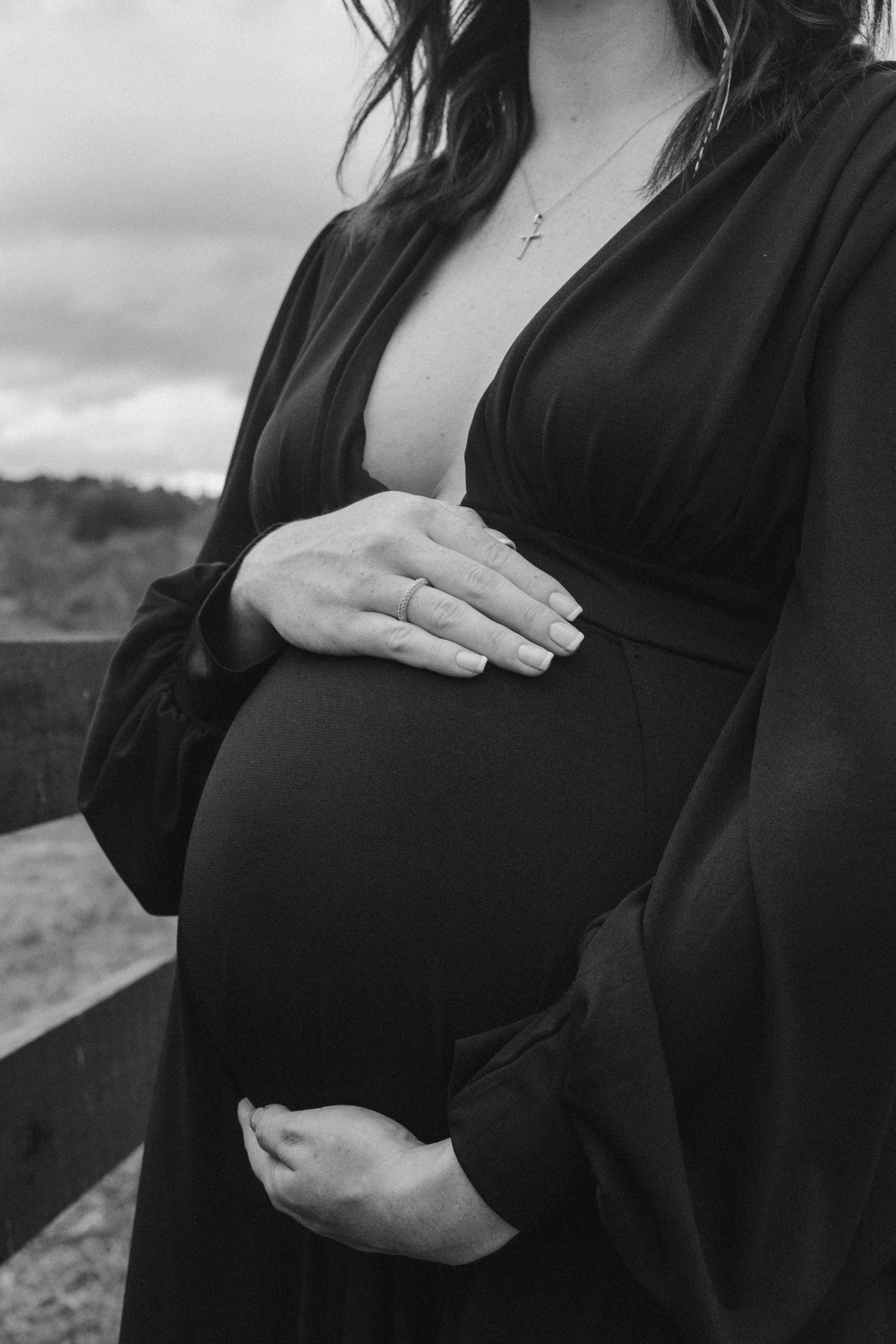 Black and white close-up shots of hands cradling a pregnant belly.