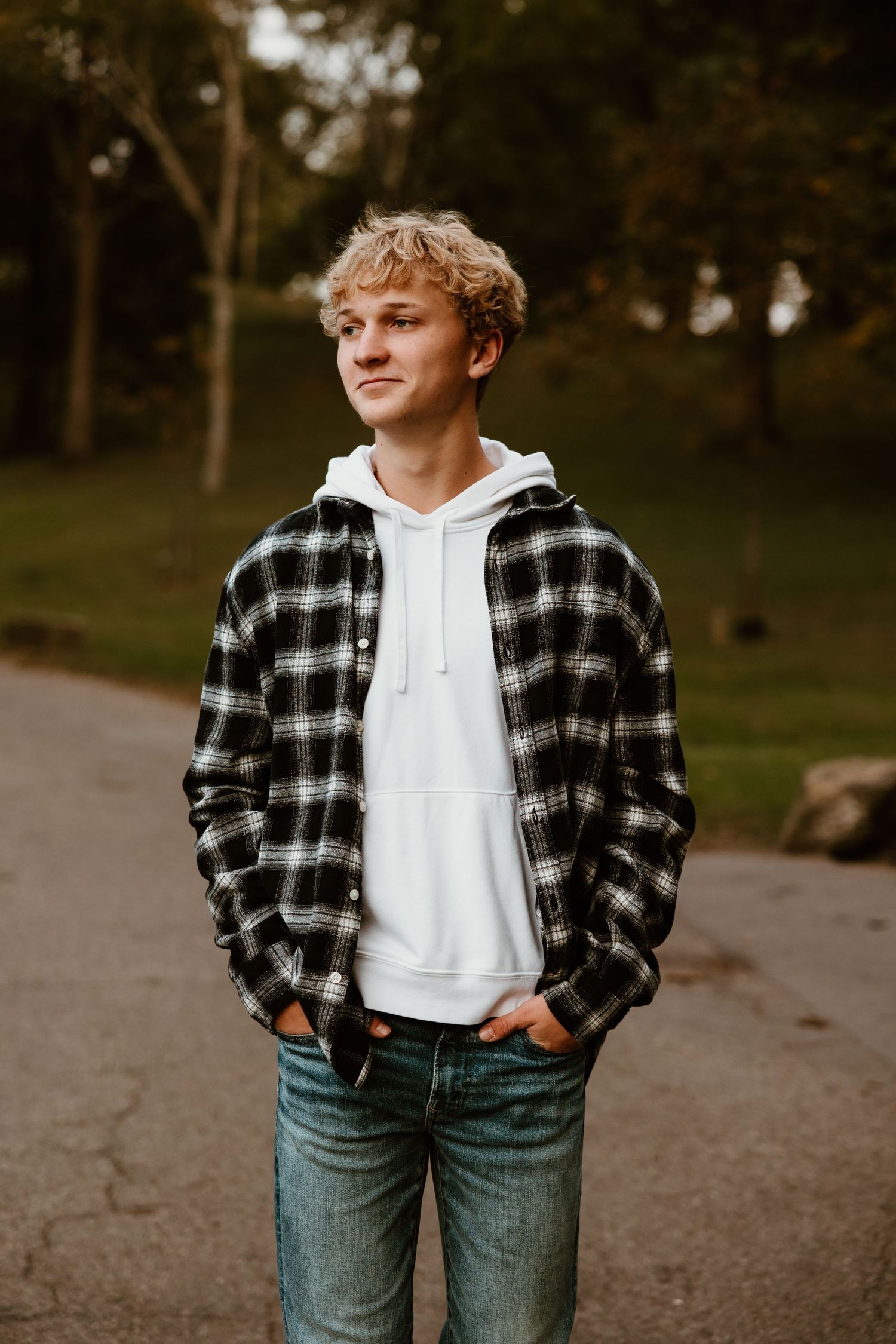 Fall outdoor portrait wearing black and white plaid flannel over white hoodie with jeans.