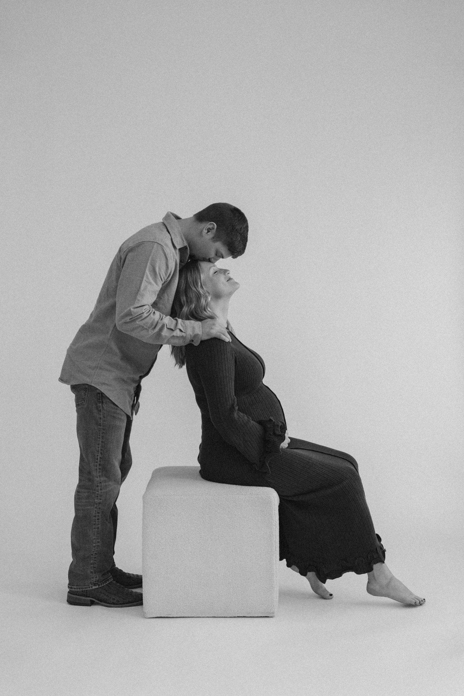 Black and white artistic photo series showing two people interacting with a white cube prop.