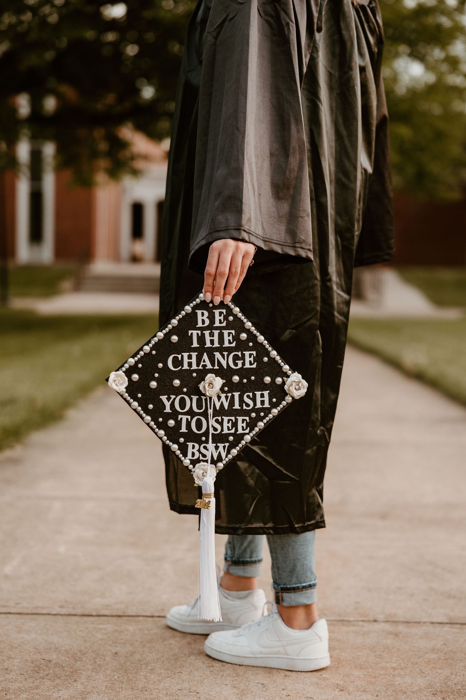 Graduation cap decorated with inspirational quote 'Be the change you wish to see'.
