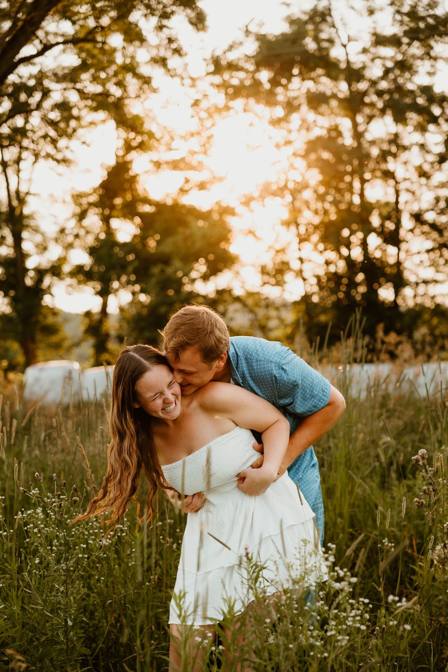 A romantic moment captured in a wildflower meadow during sunset.