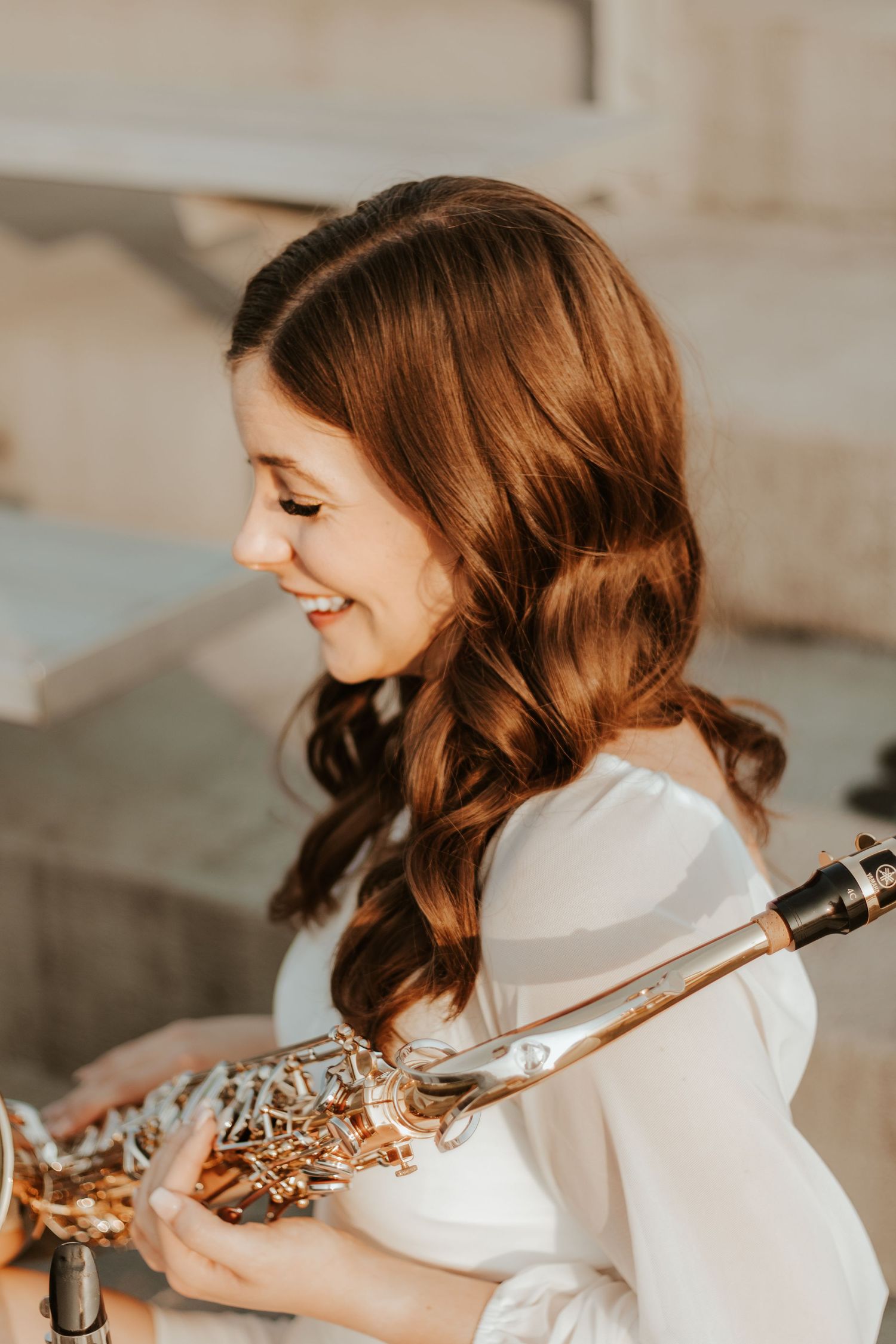 Musician in white turtleneck posing with a violin in natural lighting.
