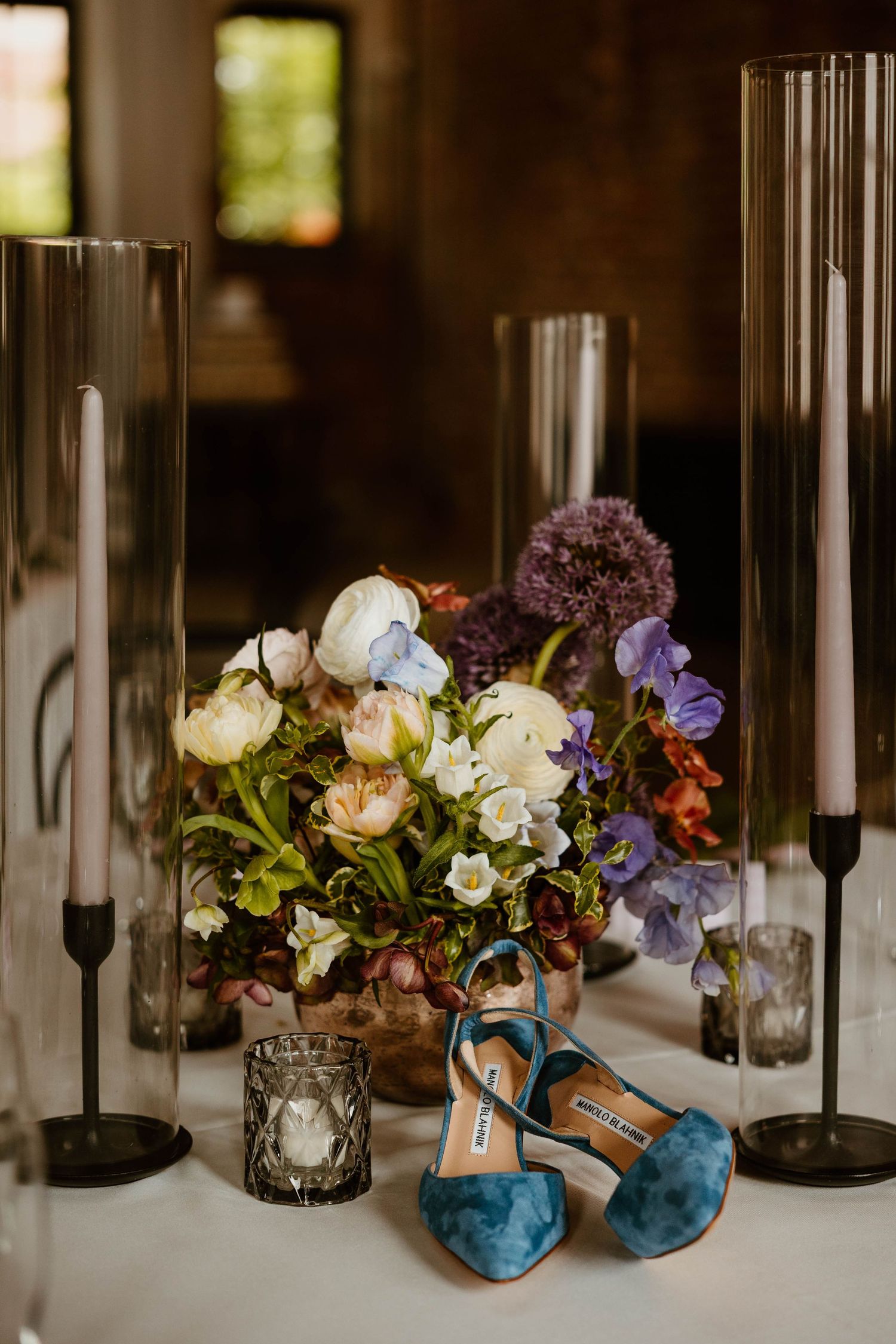 Wedding table decor featuring colorful floral arrangements with blue and purple blooms.