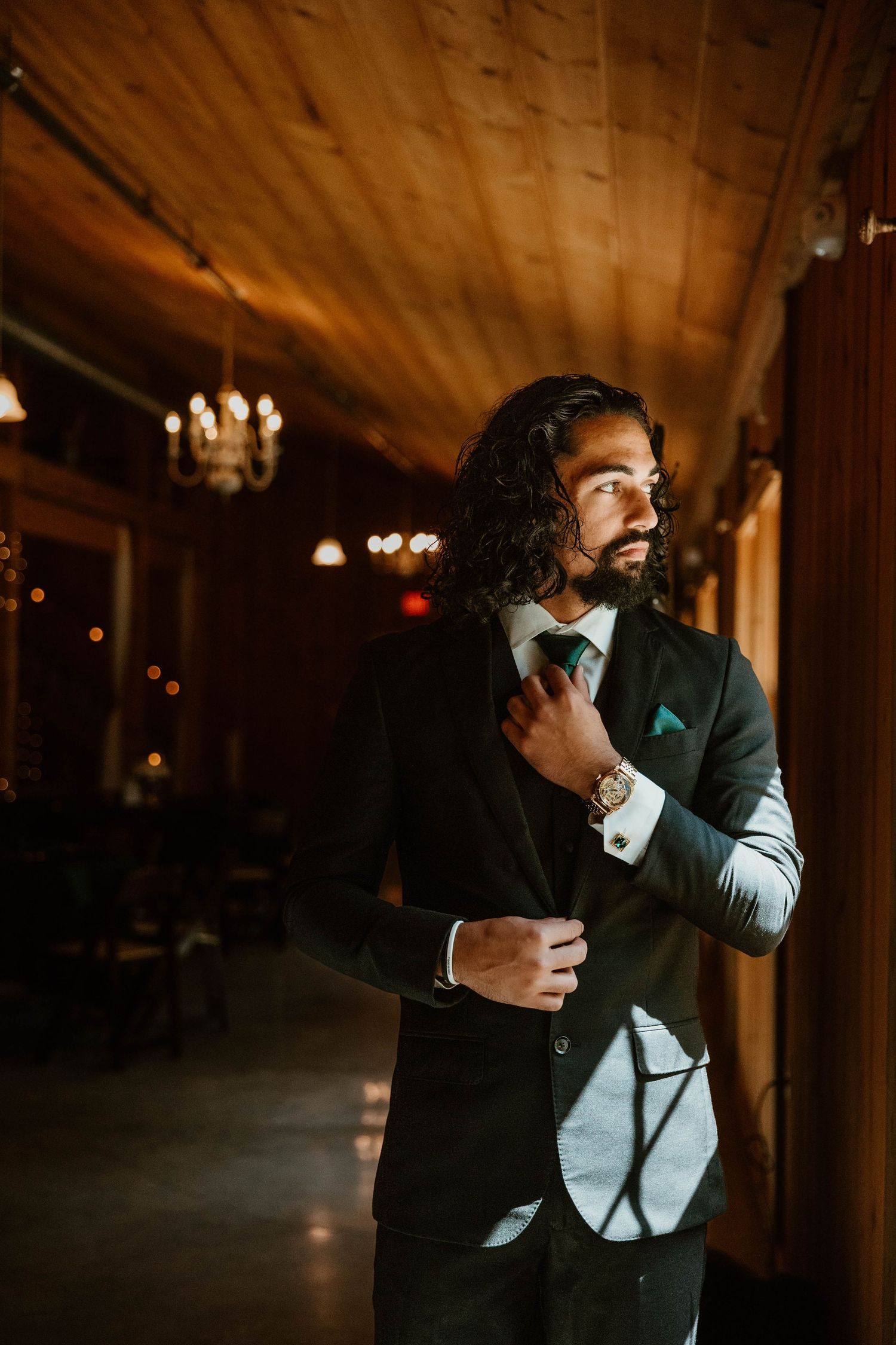 Dramatic low-light portrait of groom in dark venue.