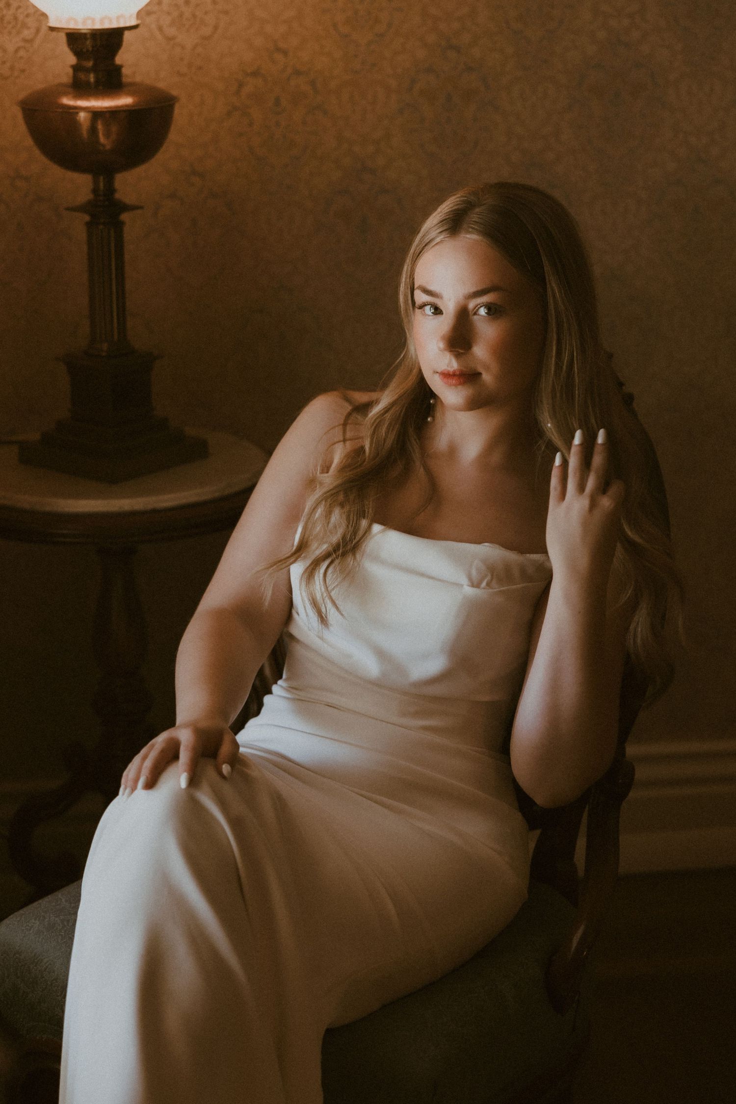 Moody bridal portrait sequence in white dress against dark background.