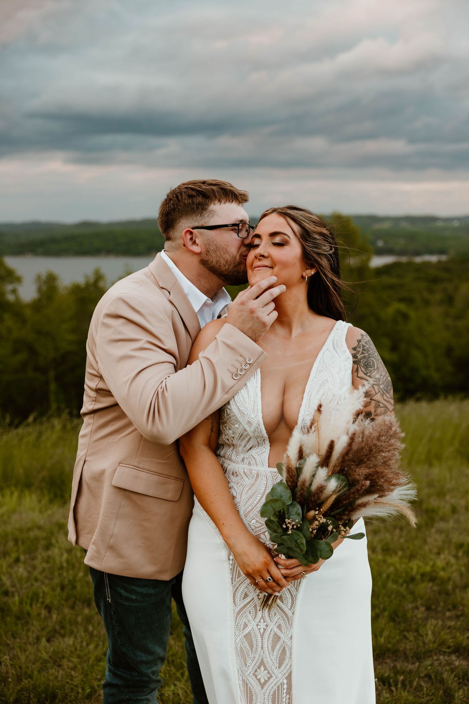 Couple shares an intimate moment in a field during their wedding photoshoot.