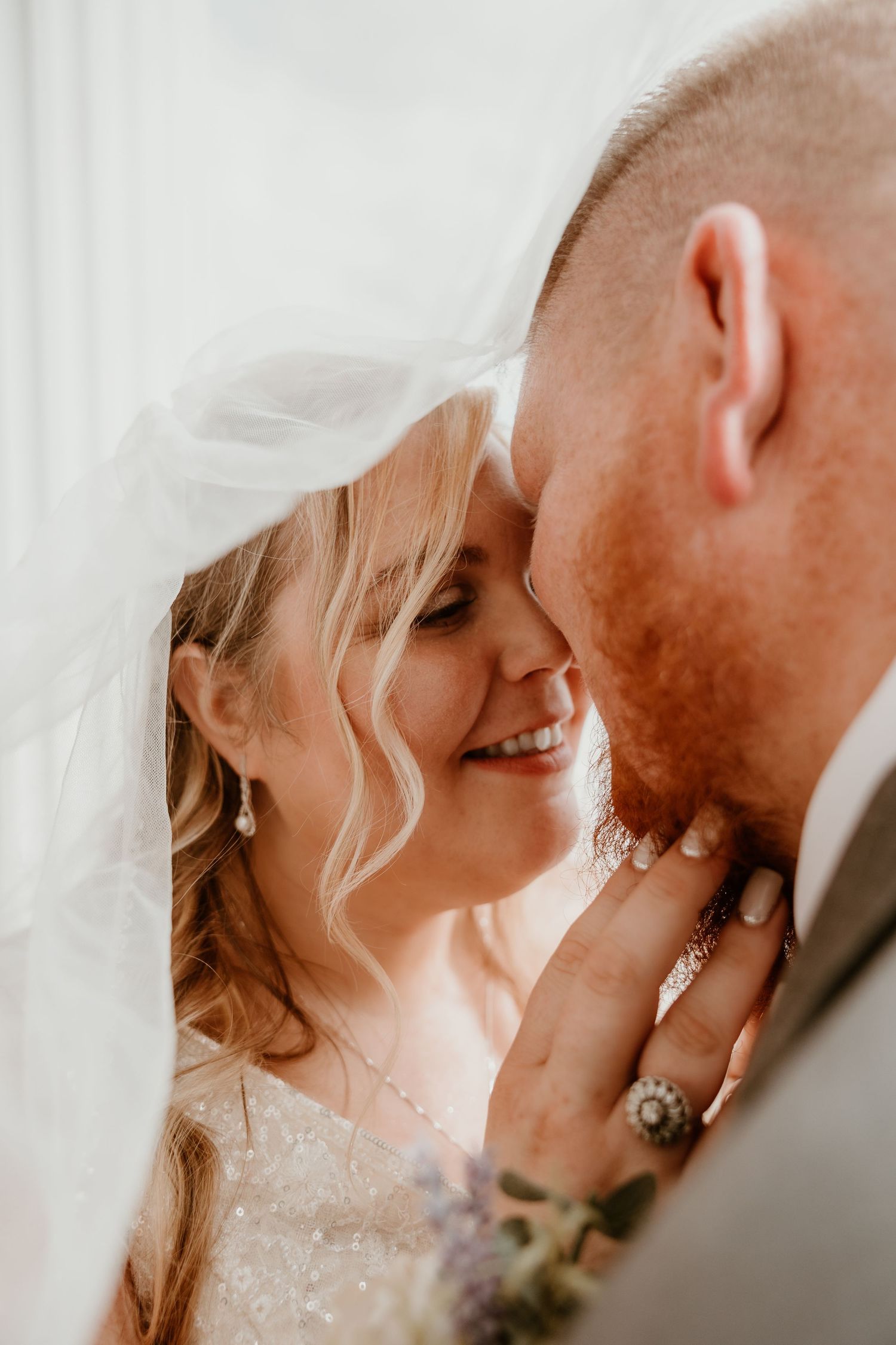 Intimate wedding portrait with soft lighting and delicate veil details.