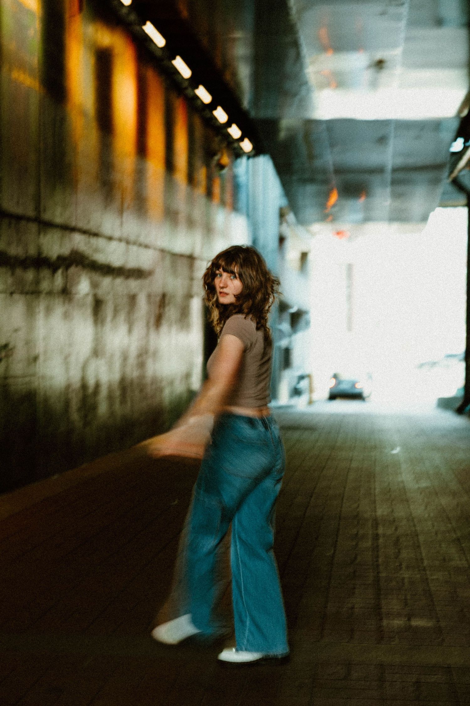 Artistic photo sequence in a dimly lit corridor showing movement and dance in teal clothing.