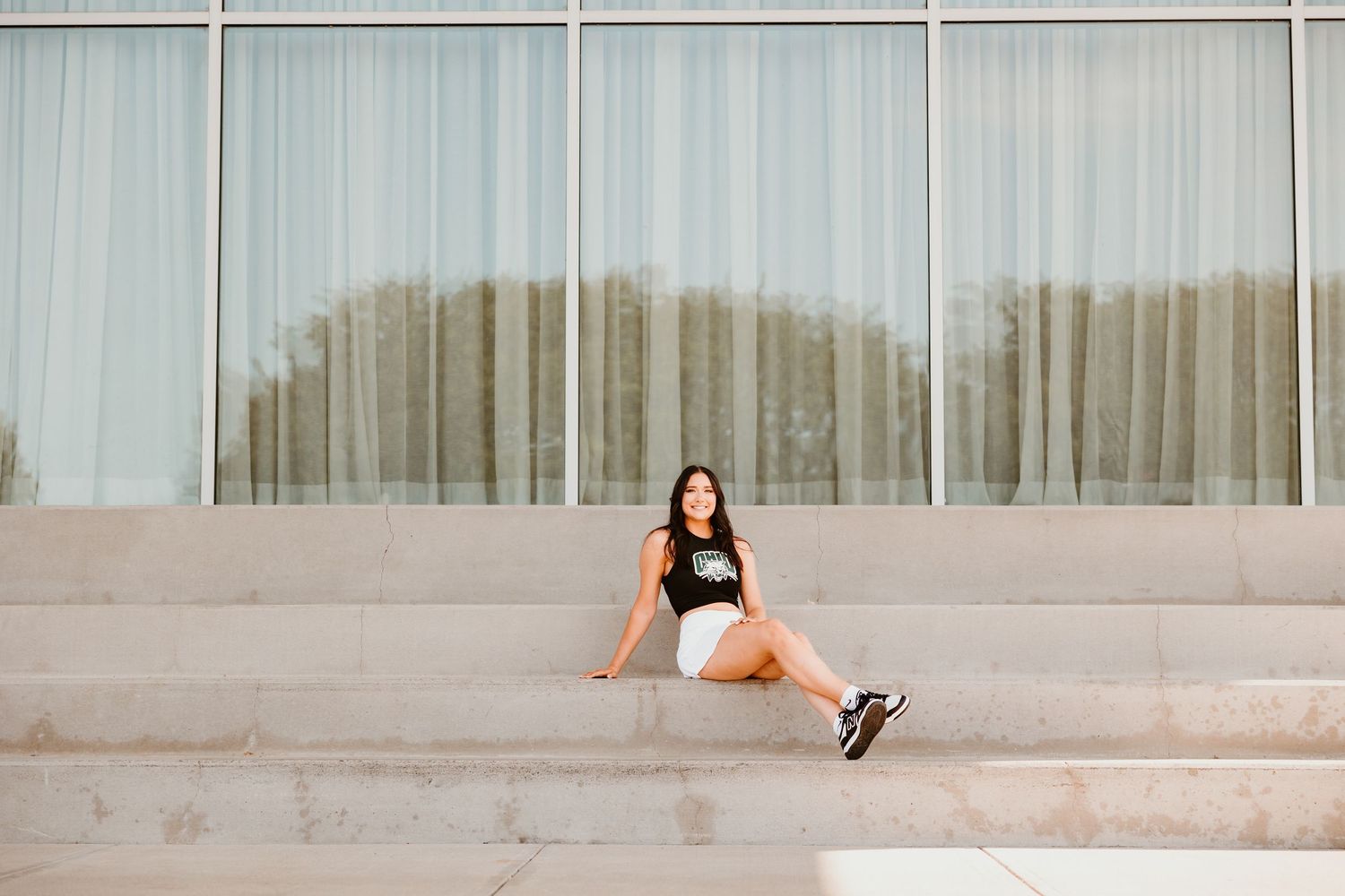 Modern architectural setting with glass windows and concrete elements for minimalist portrait.
