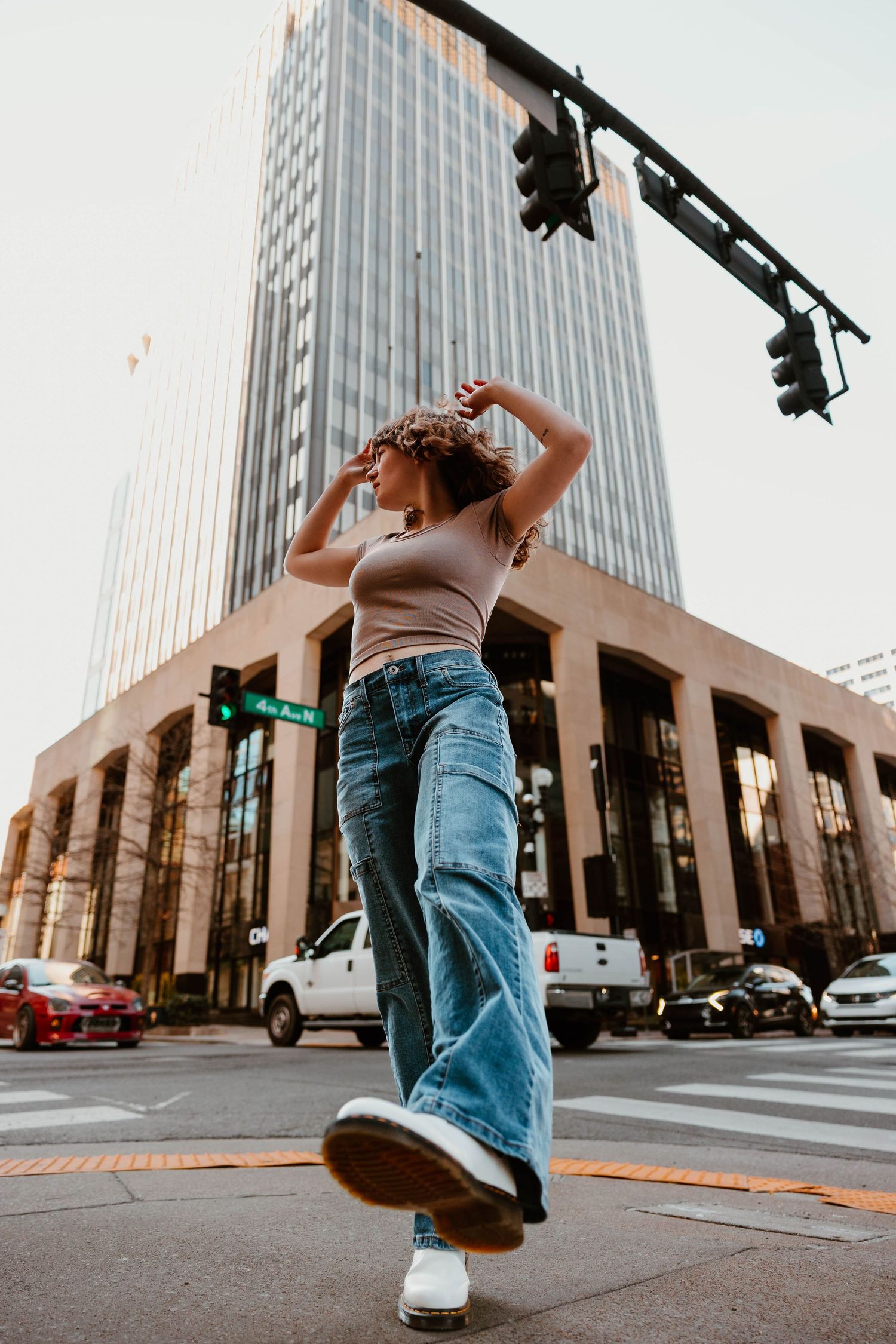 Urban dance sequence photographed from low angle with modern architecture in background.