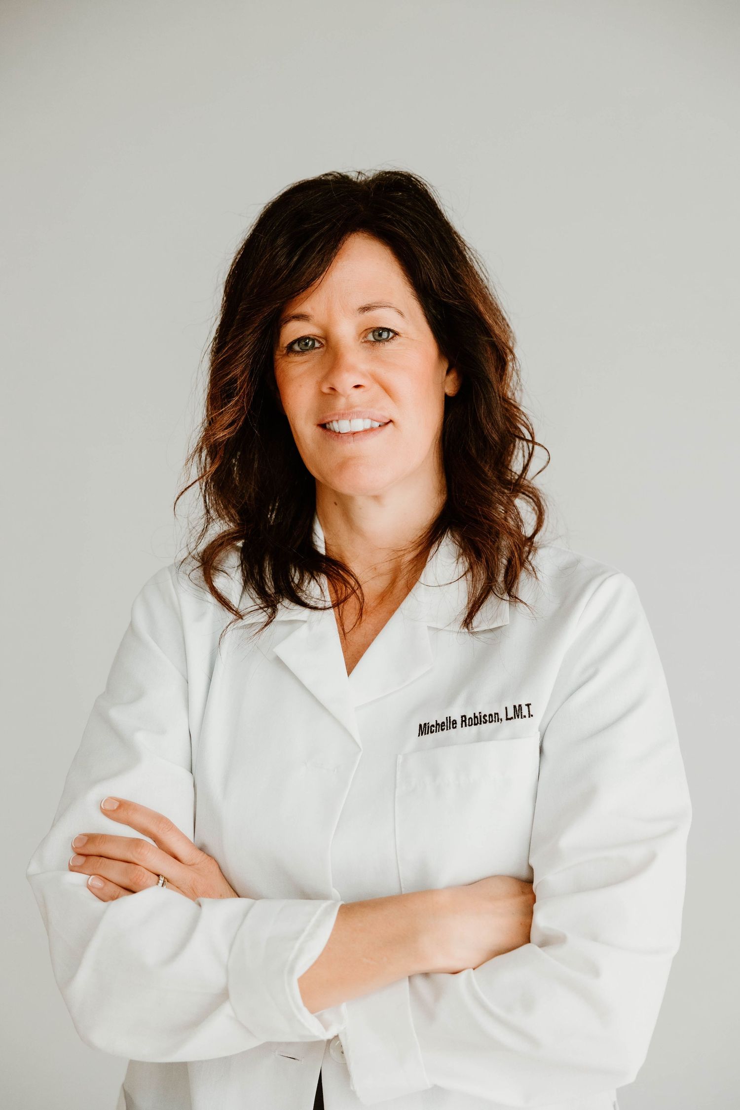 Series of professional portraits in white medical coat against light gray background.