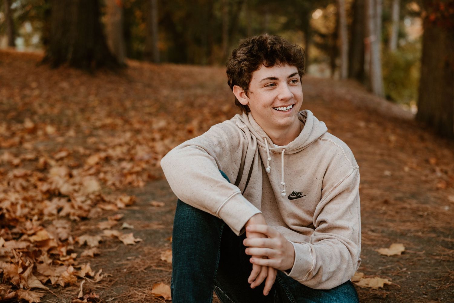 Casual portrait series in autumn setting with fallen leaves and natural lighting.