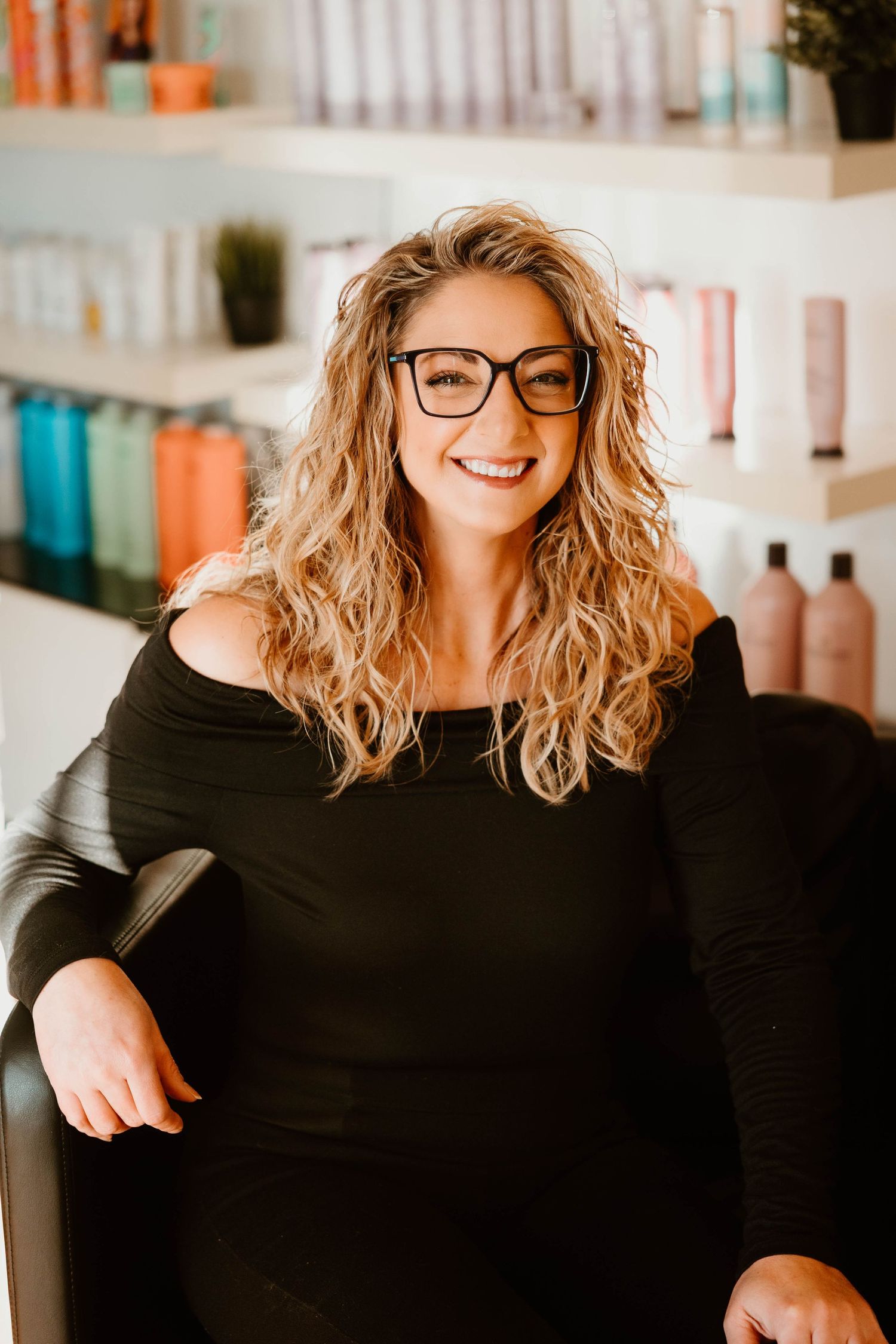 Modern salon interior with product display shelves showcasing hair care items in bright lighting.
