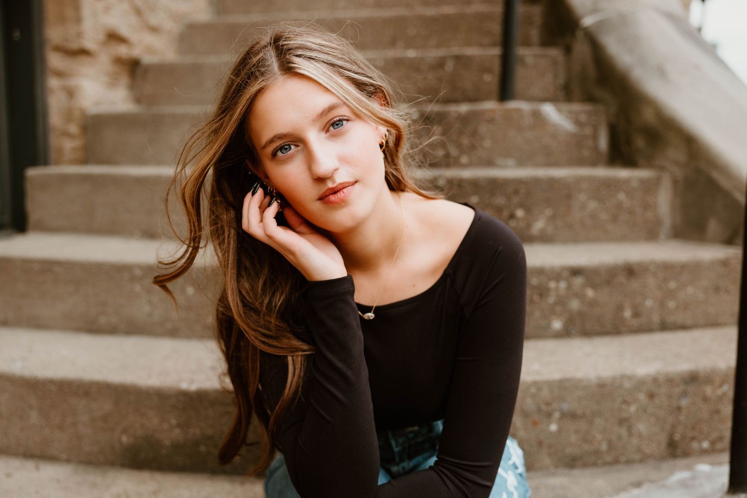 Artistic portrait series showing a person in black clothing against stairs in moody lighting.