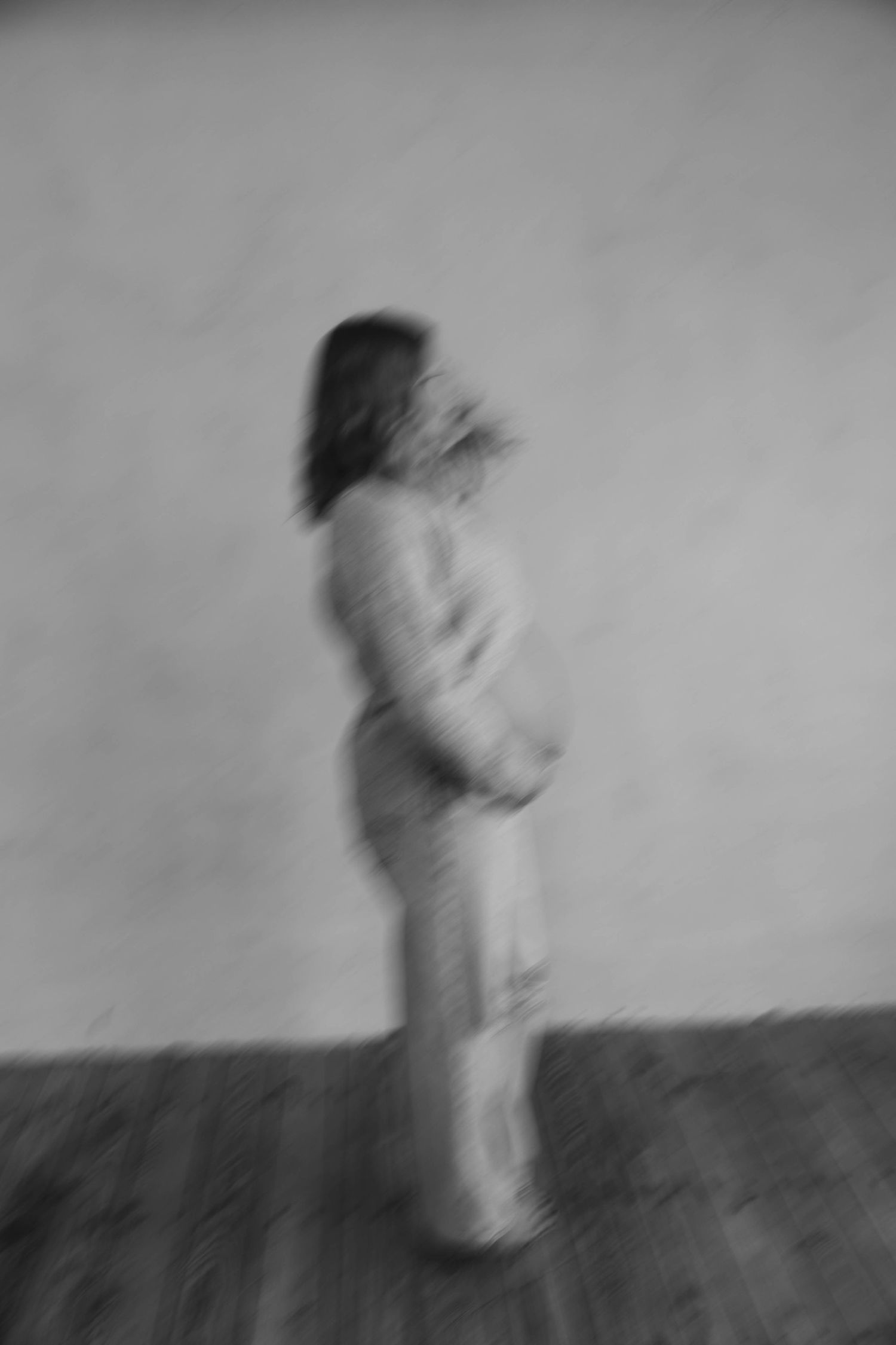 Blurry black and white motion sequence showing a figure walking across the frame.