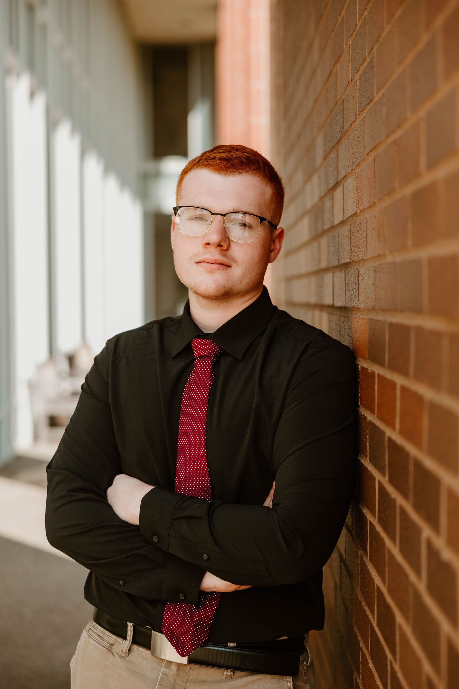 Professional headshots against brick wall featuring business attire and burgundy tie.
