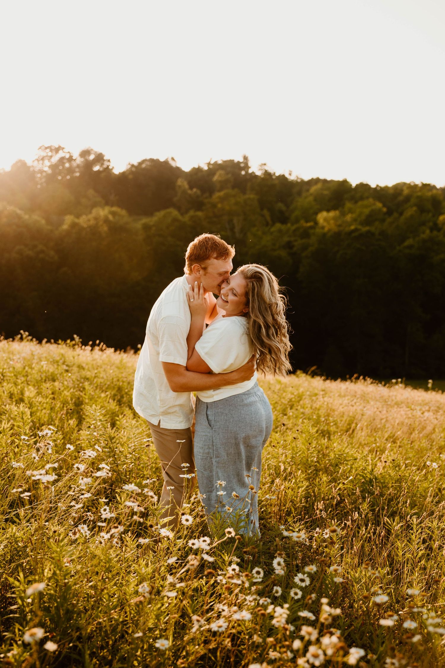 An intimate moment shared between two people in a sun-drenched wildflower meadow.