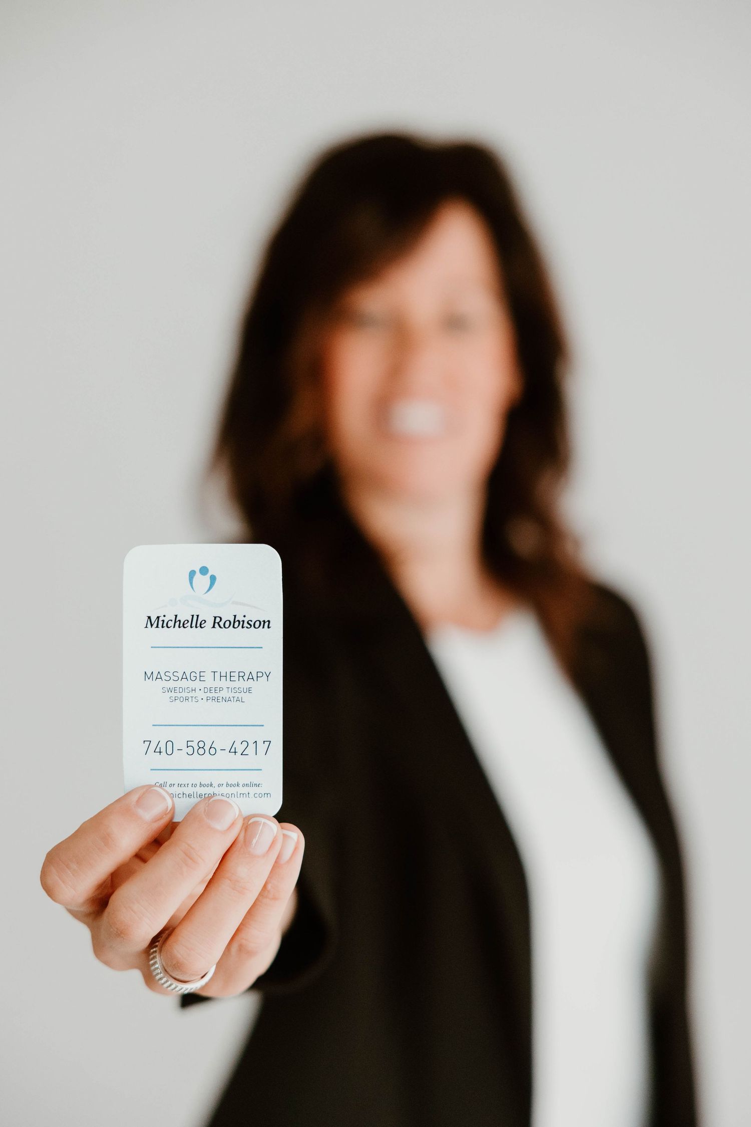 Business card presentation series showing contact information for massage therapy services.