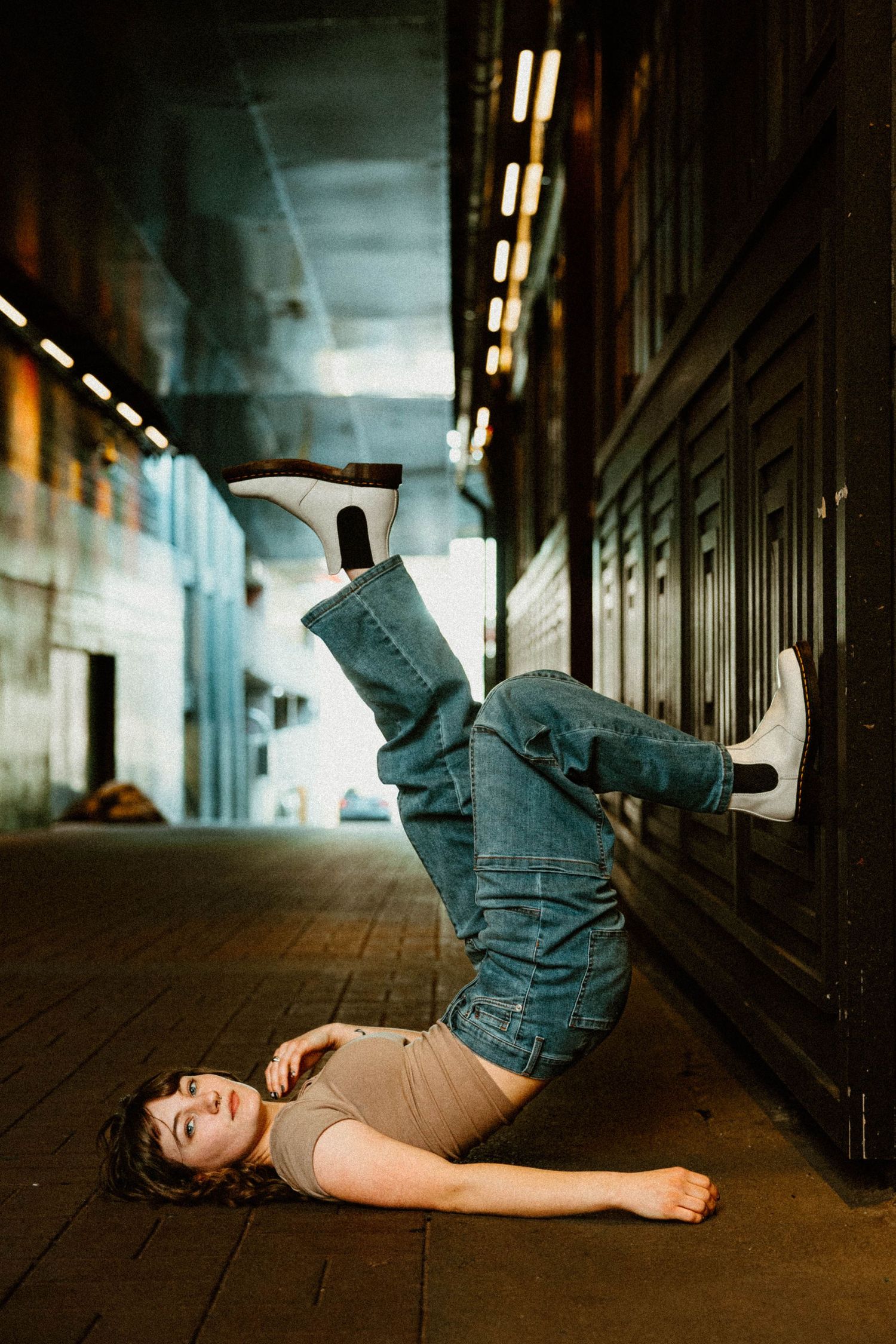Creative movement sequence photographed in industrial hallway with dramatic lighting.