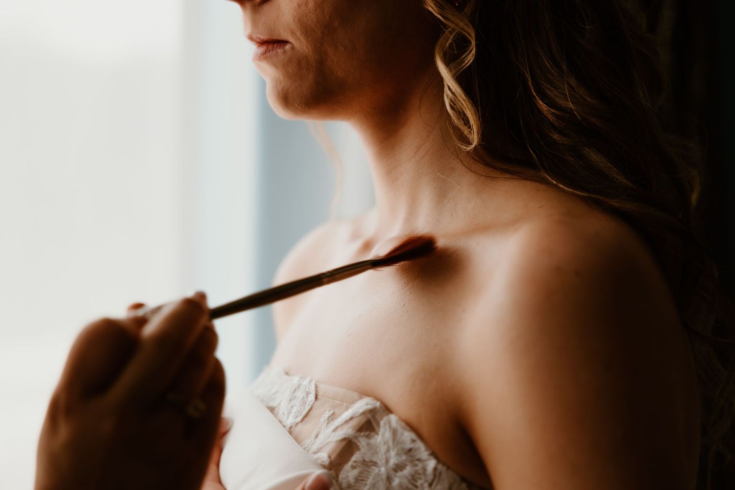 Soft, intimate getting-ready moments captured in silhouette during wedding preparations.