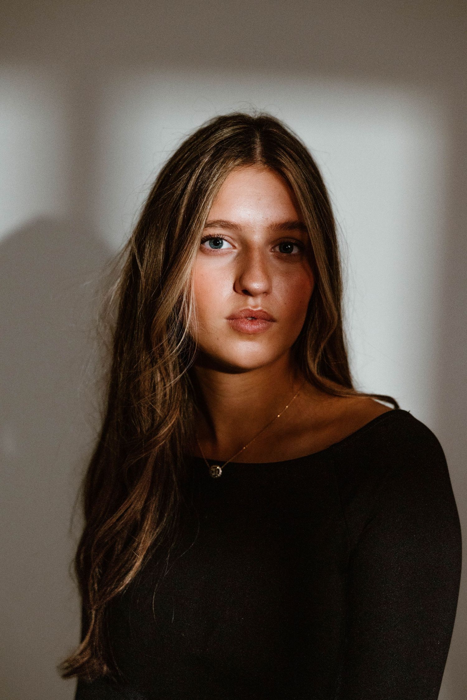 Dramatic close-up portraits in dark tones with strong shadow contrast.