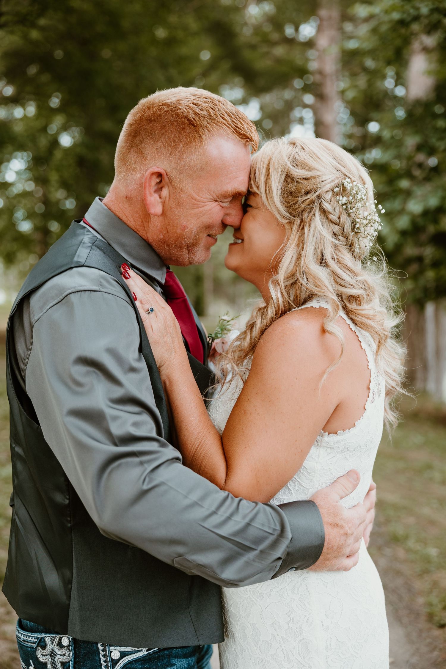 A tender moment between newlyweds in an outdoor garden setting.