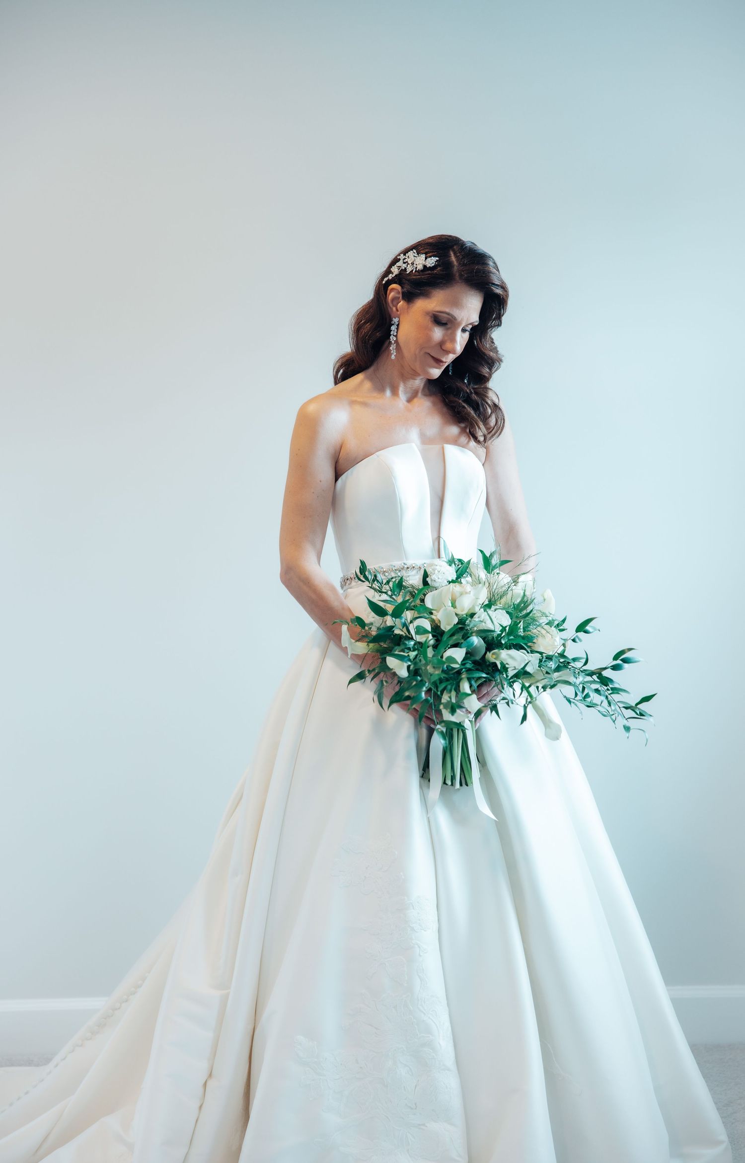 Bride holding flower bouquet on day of wedding while waiting for groom.