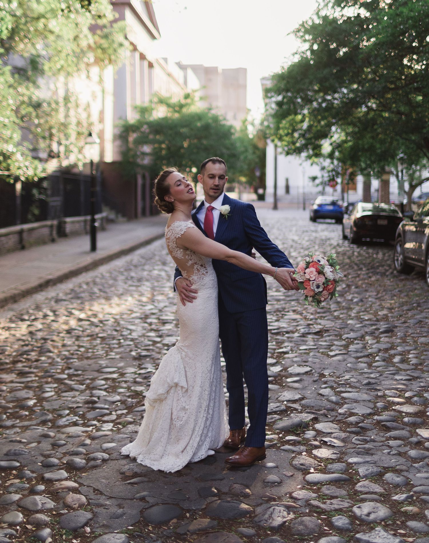 Bride and groom celebrating their wedding day on Chalmers street in Charleston, SC. where the cobblestones steal the show.