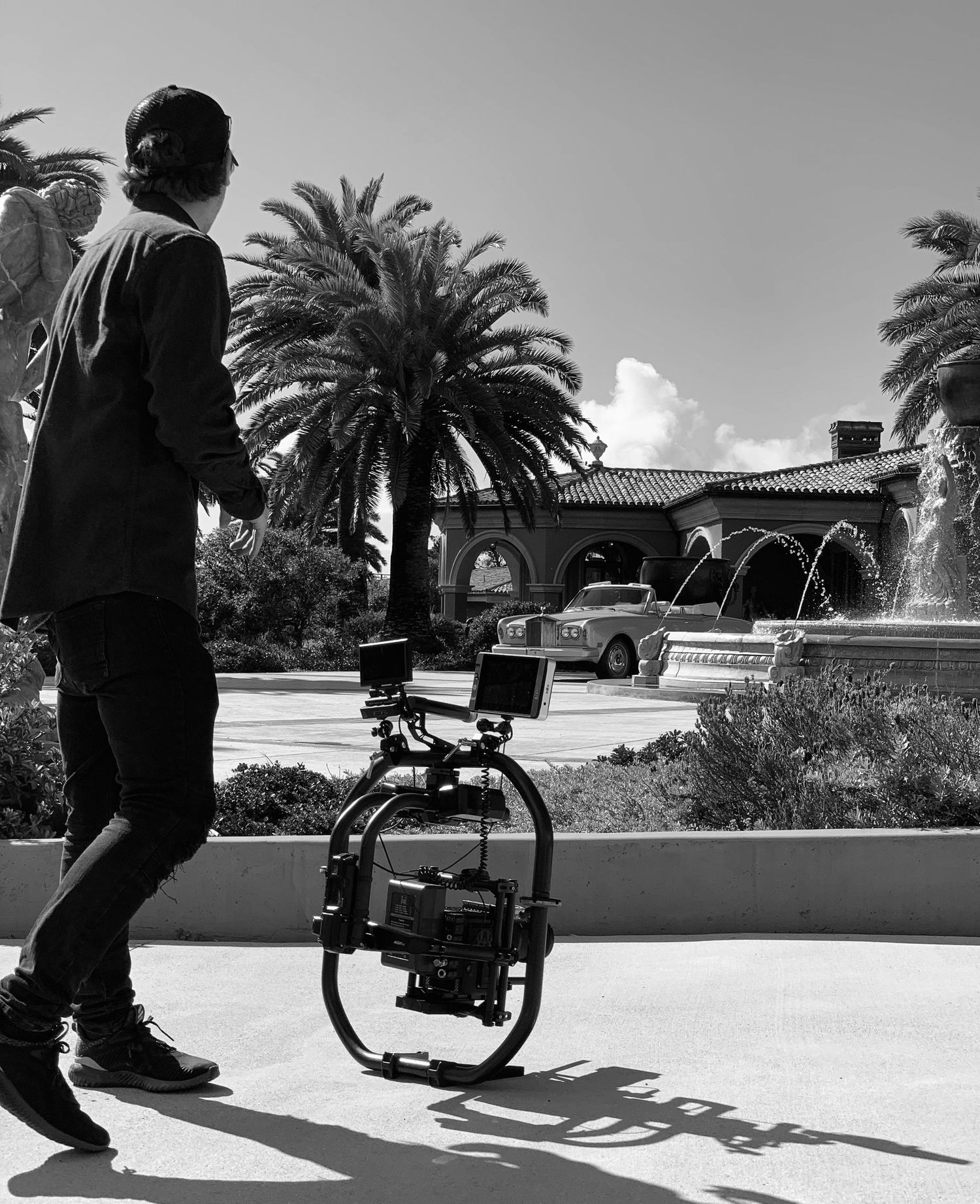 Man with video camera looking over luxury estate
